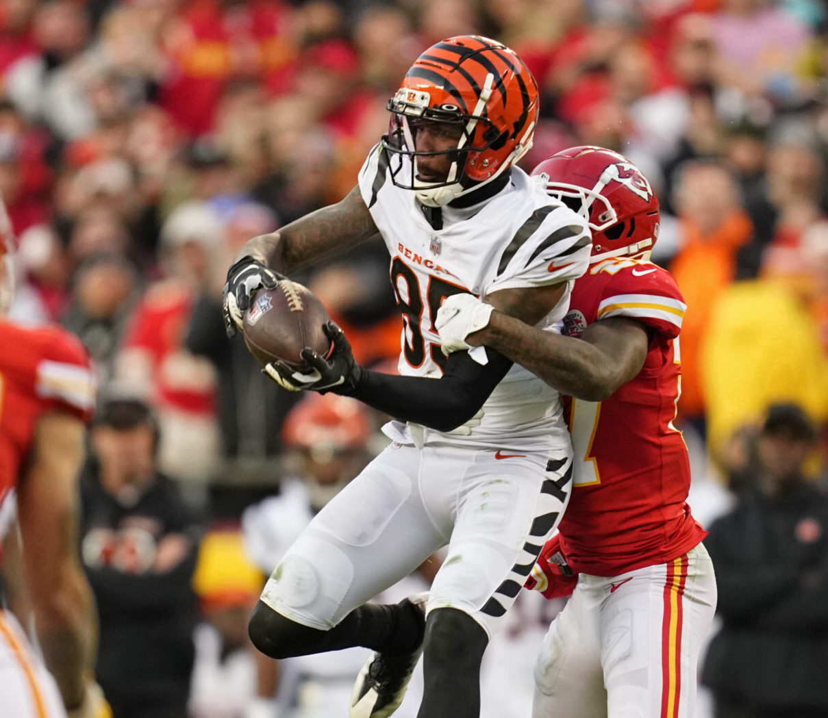 Jan 30, 2022; Kansas City, Missouri, USA; Cincinnati Bengals wide receiver Tee Higgins (85) makes a catch against Kansas City Chiefs cornerback Rashad Fenton (27) during overtime of the AFC Championship Game at GEHA Field at Arrowhead Stadium. The Cincinnati Bengals won 27-24.