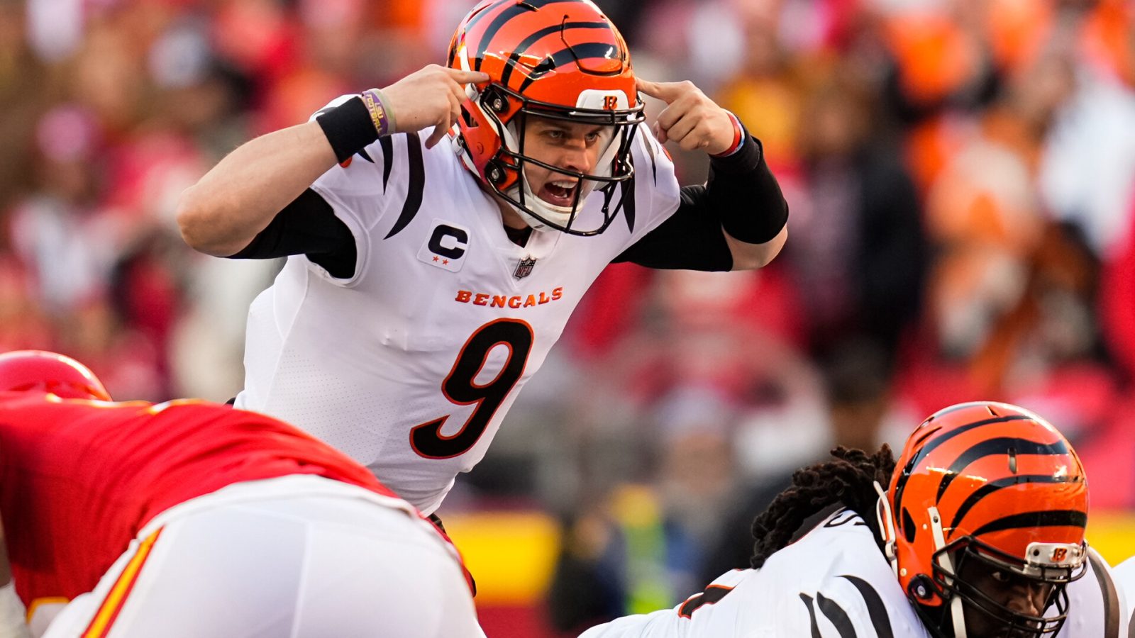 Cincinnati Bengals quarterback Joe Burrow points to his helmet with both index fingers to alert his teammates prior to a snap against the Kansas City Chiefs