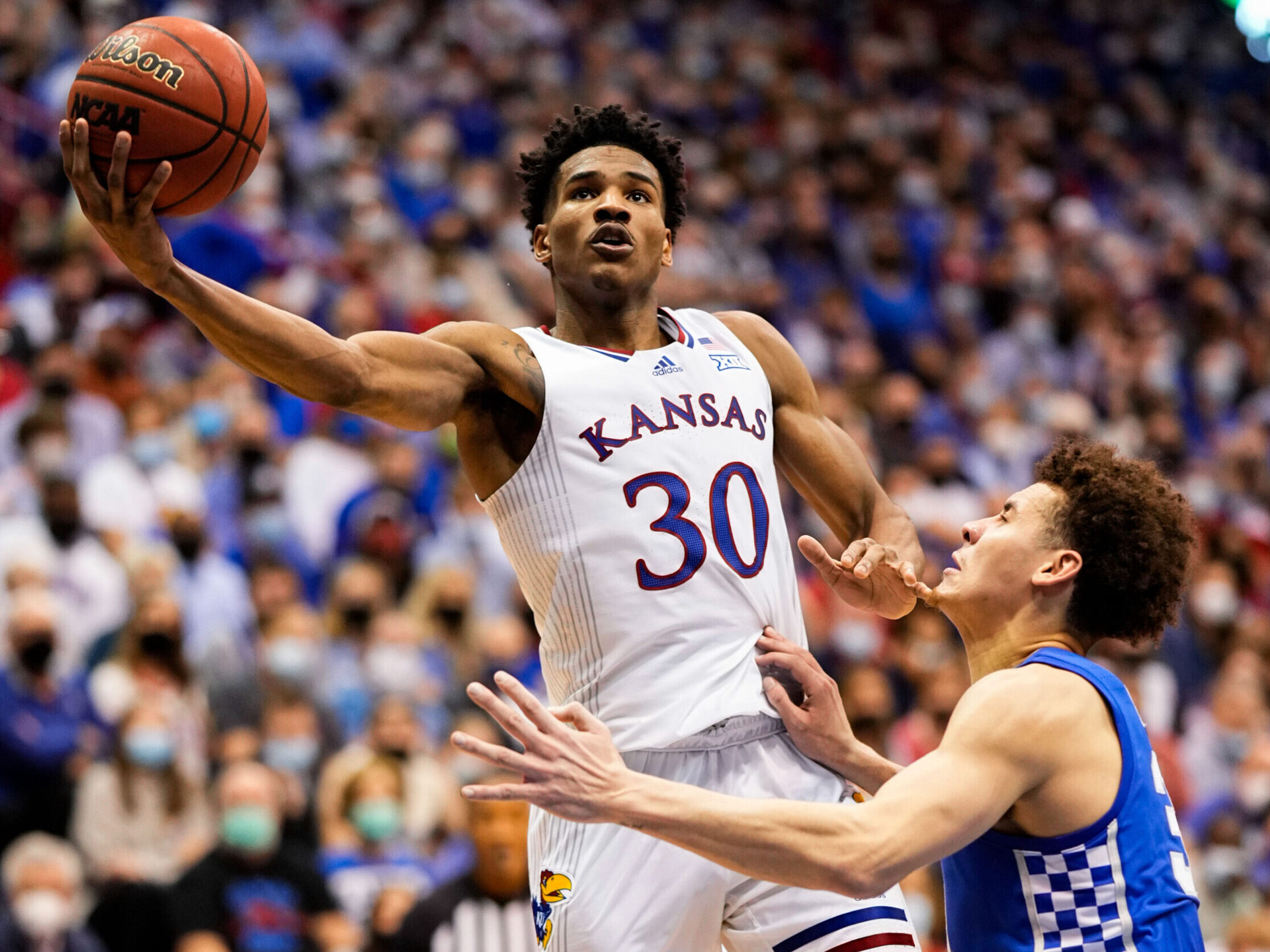 Kansas Jayhawks guard Ochai Agbaji (left) shoots against Kentucky Wildcats guard Kellan Grady (right)