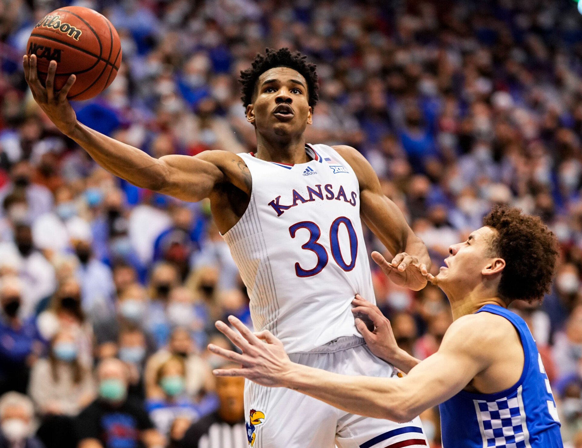 Kansas Jayhawks guard Ochai Agbaji (left) shoots against Kentucky Wildcats guard Kellan Grady (right) during an SEC/Big 12 Challenge basketball game at Kansas