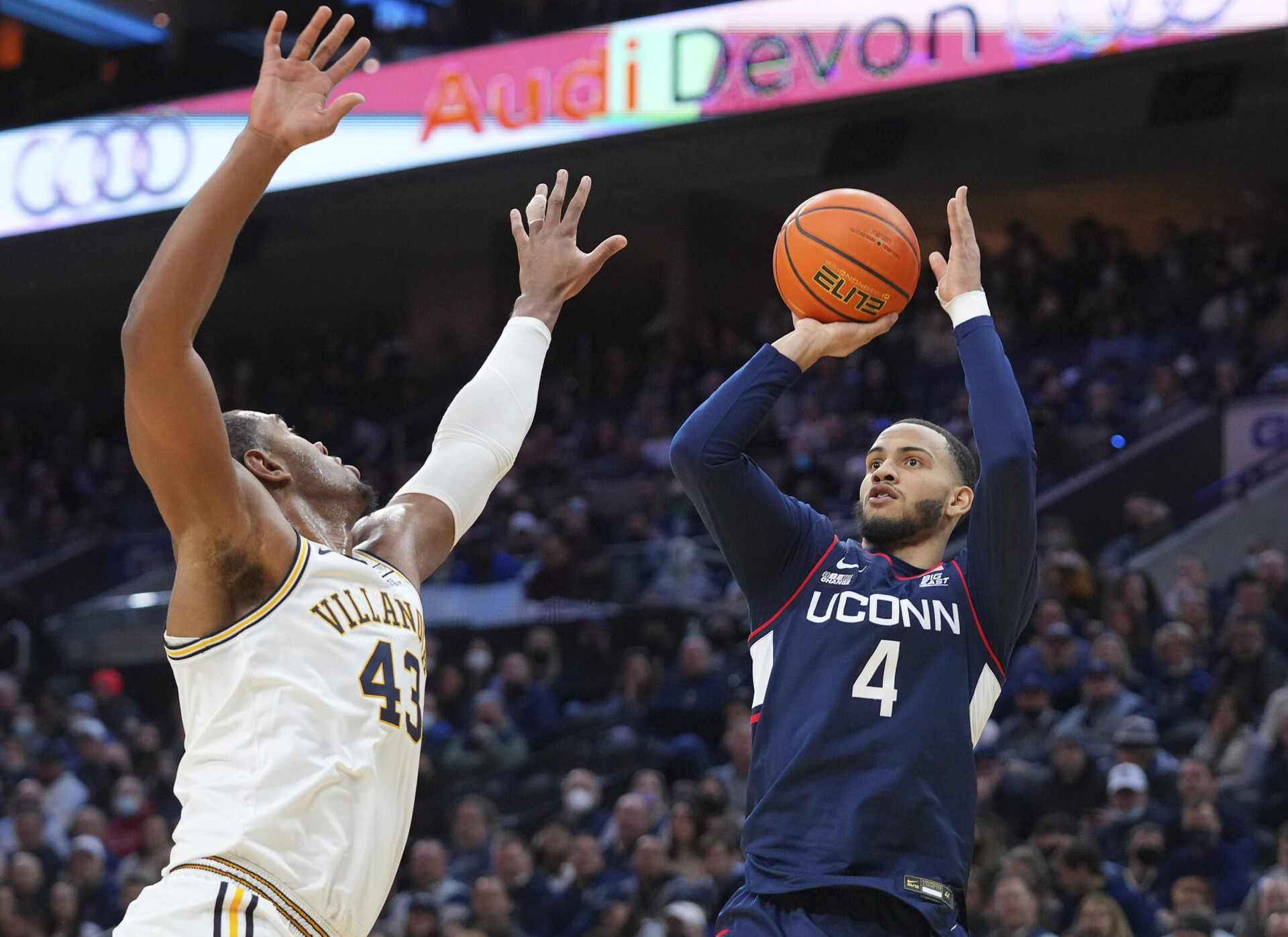 Connecticut Huskies guard Tyrese Martin (right) shoots the ball over the outstretched arm of Villanova Wildcats forward Eric Dixon (left) during a Big East basketball game