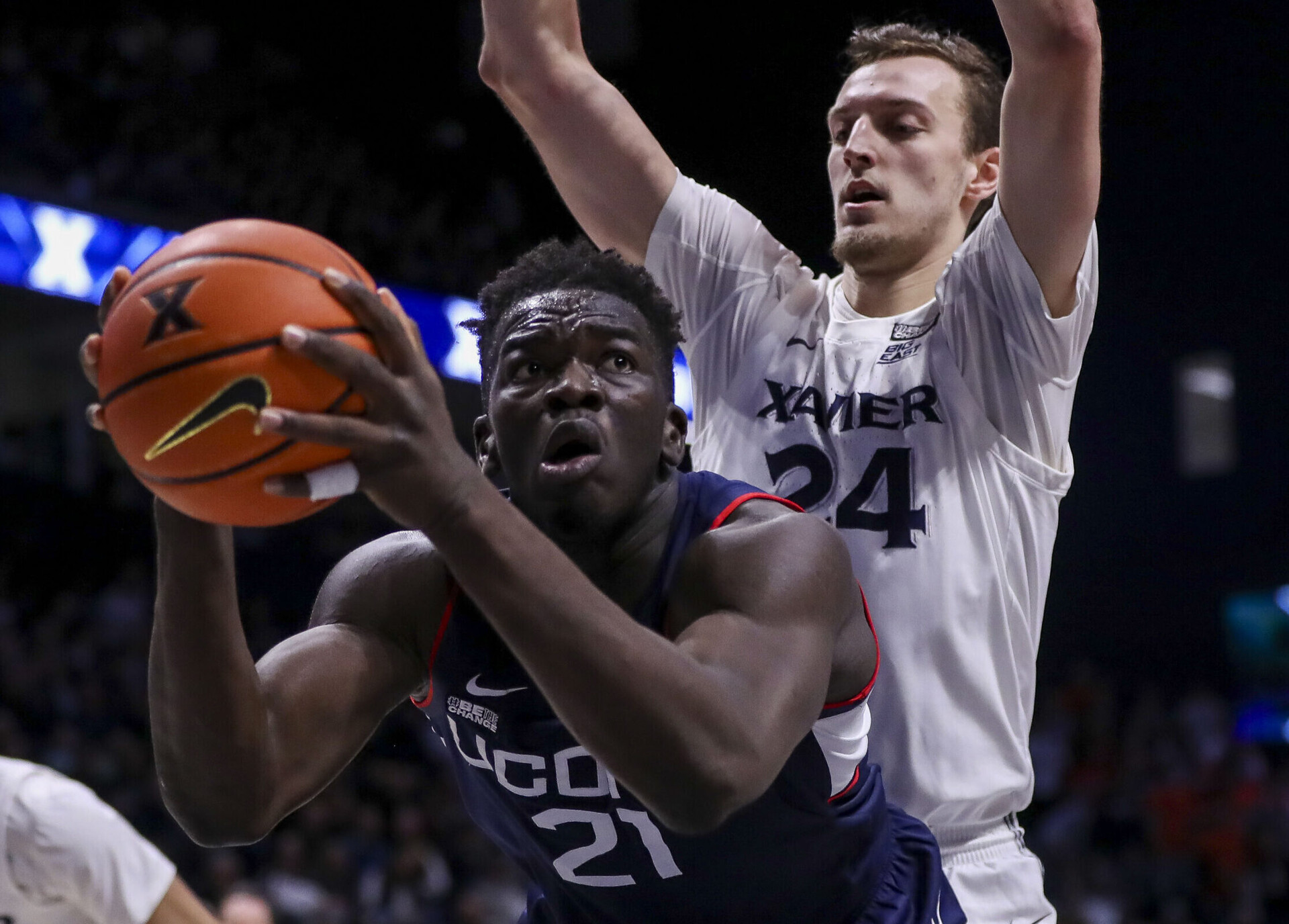Connecticut Huskies forward Adama Sanogo (left) controls the ball against Xavier Musketeers forward Jack Nunge (right) during a Big East basketball game