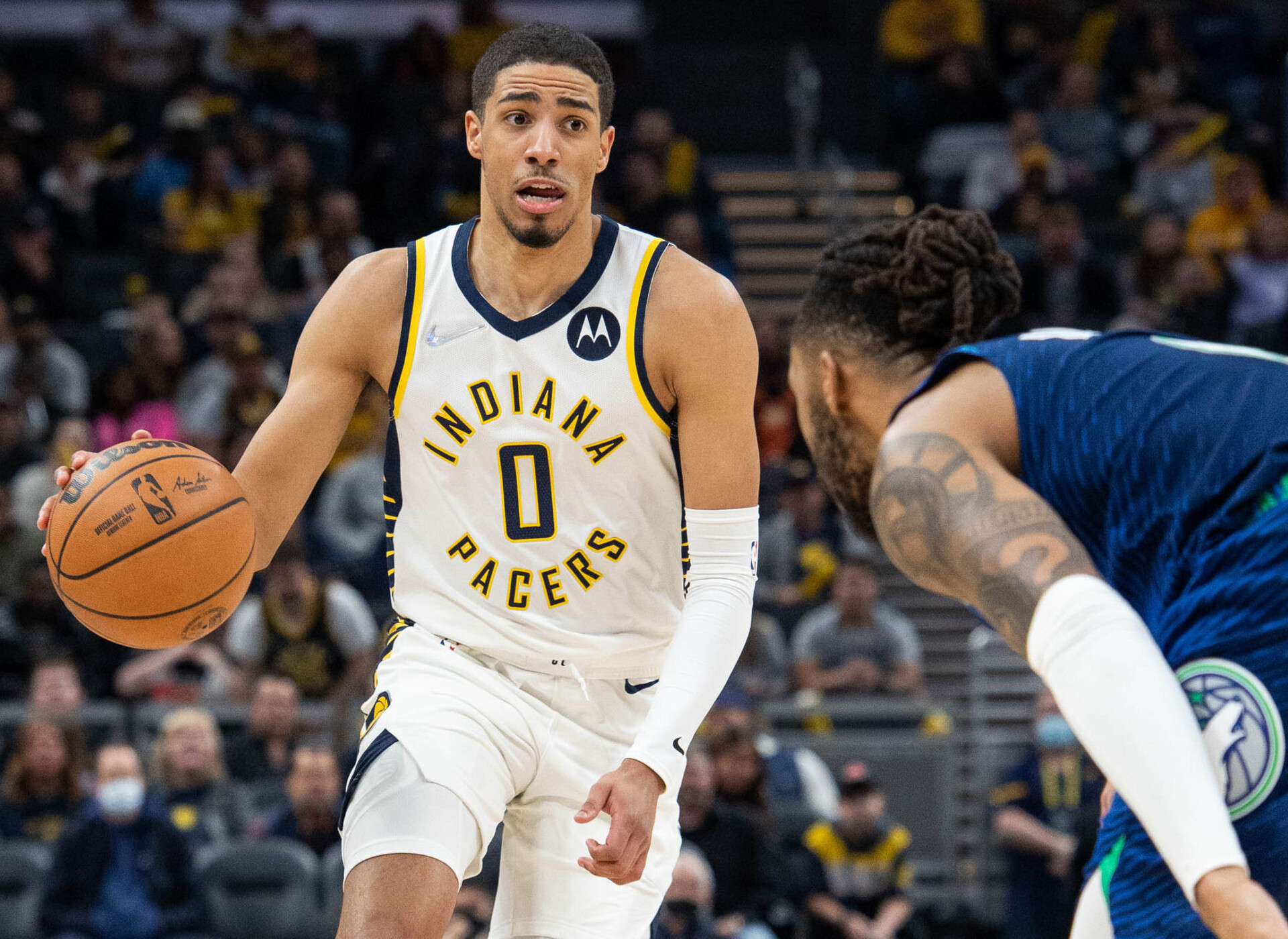 Indiana Pacers guard Tyrese Haliburton (left) dribbles the ball while Minnesota Timberwolves guard D'Angelo Russell (right) defends
