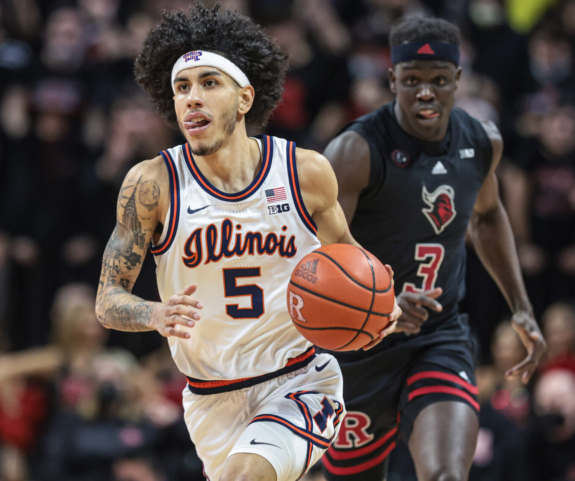 Illinois Fighting Illini guard Andre Curbelo (left) dribbles up court in front of Rutgers Scarlet Knights forward Mawot Mag (right) during a Big Ten basketball game
