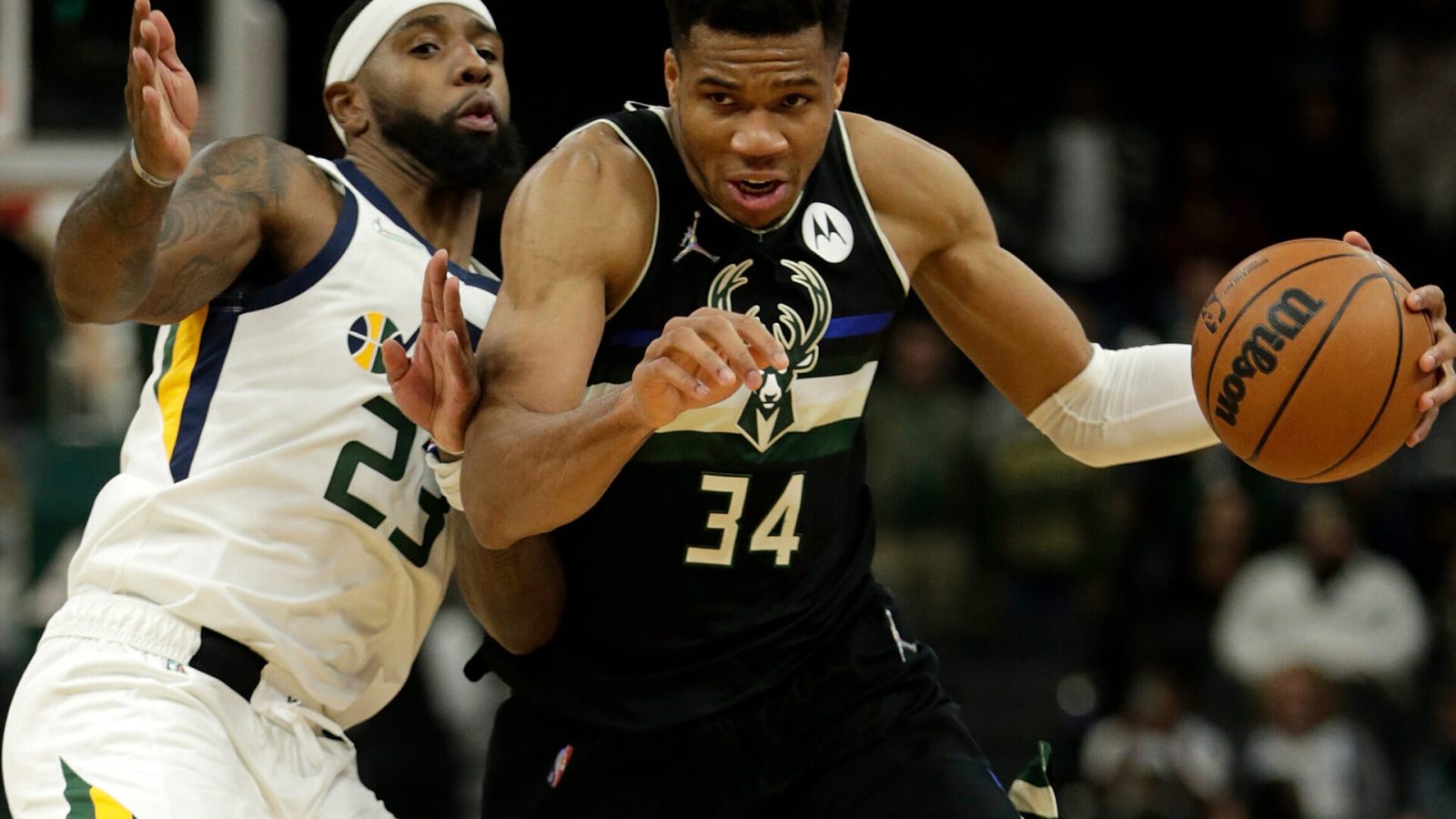Giannis Antetokounmpo #34 of the Milwaukee Bucks dribbles past Royce O'Neale #23 of the Utah Jazz during the second half of a game at Fiserv Forum on October 31, 2021 in Milwaukee, Wisconsin.