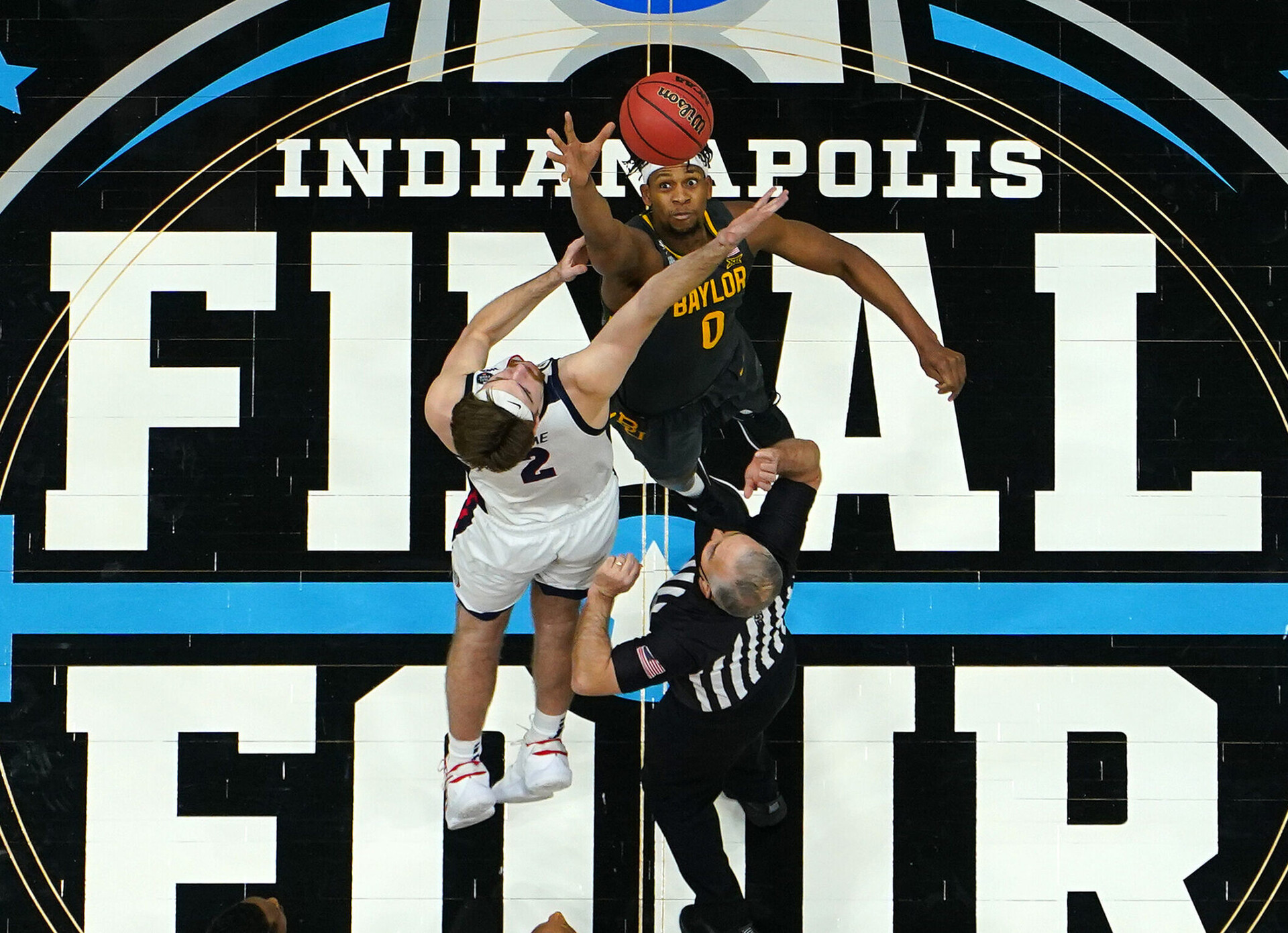 Gonzaga Bulldogs center Drew Timme (left) and Baylor Bears center Flo Thamba (right) jump for the basketball during tip off of the 2021 NCAA national championship game in Indianapolis