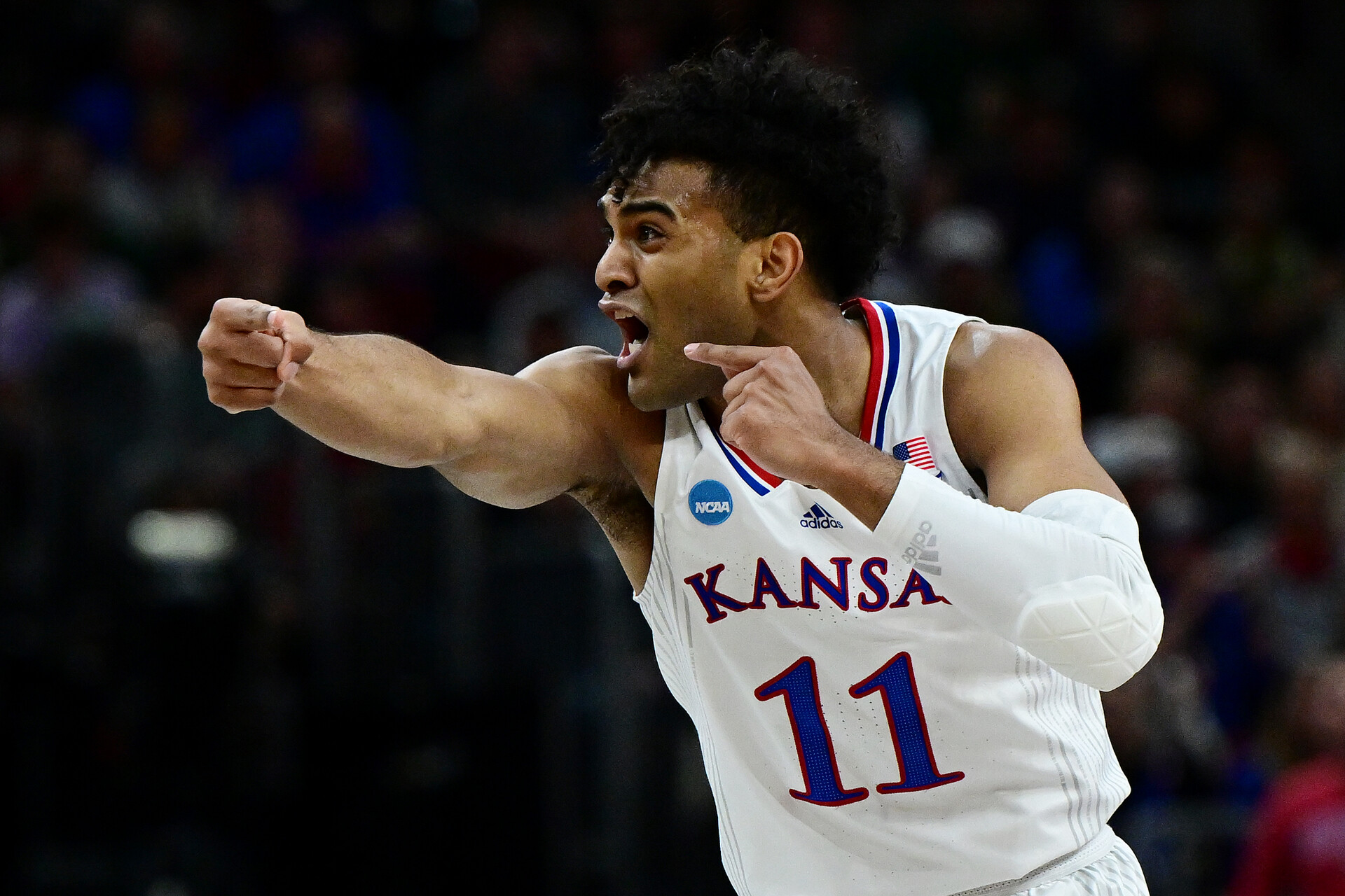 Kansas Jayhawk point guard Remy Martin points with his right hand and shouts instructions to a teammate during an NCAA Tournament Sweet 16 game against the Providence Friars
