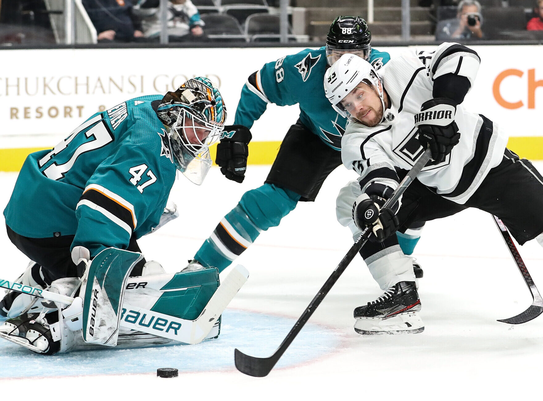 San Jose Sharks goaltender Jack Reimer (left) makes a save on a shot by Los Angeles Kings player Viktor Arvidsson (right)