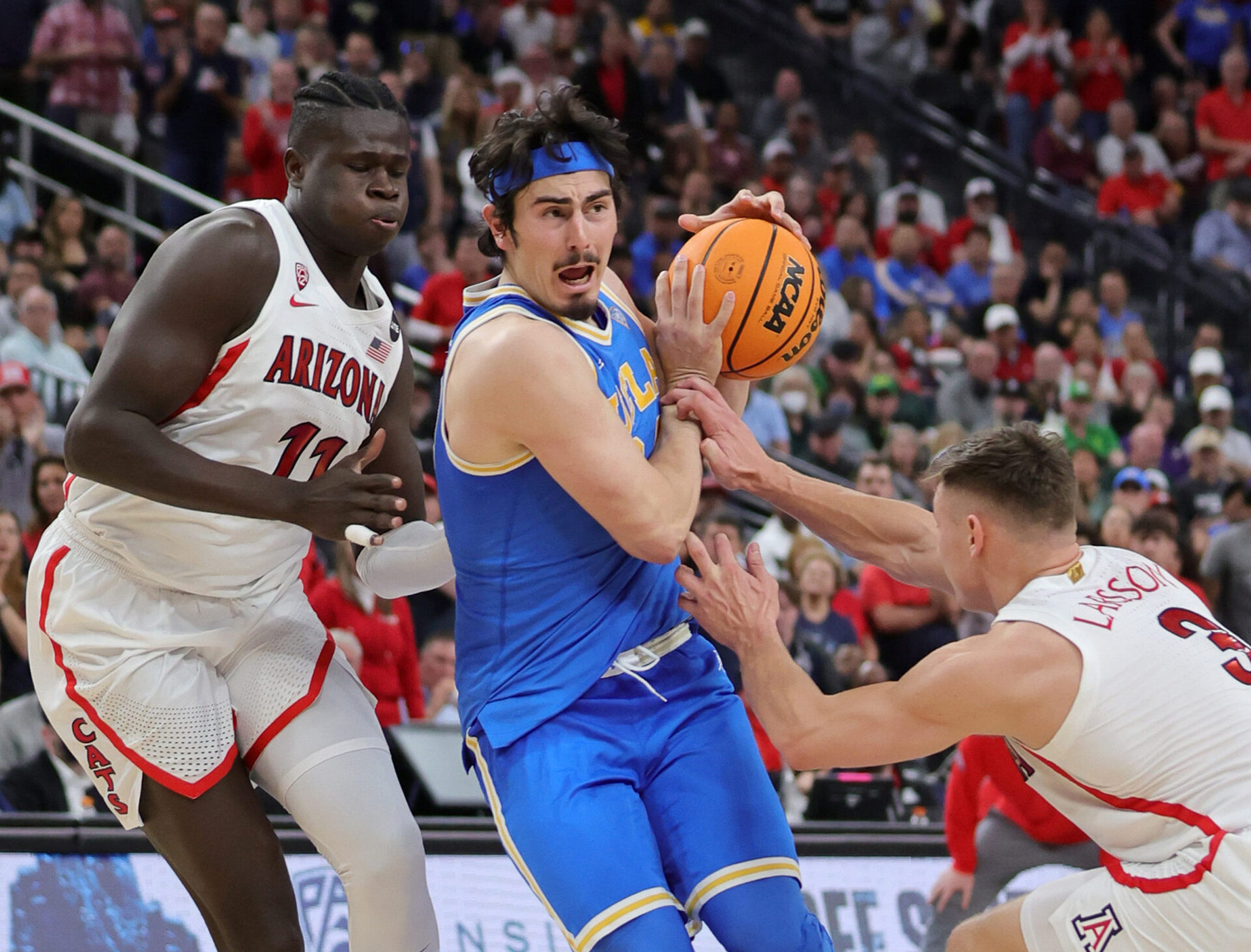 Jaime Jaquez Jr. #24 of the UCLA Bruins is guarded by Christian Koloko #35 and Pelle Larsson #3 of the Arizona Wildcats during the Pac-12 Conference basketball tournament championship game at T-Mobile Arena on March 12, 2022 in Las Vegas, Nevada