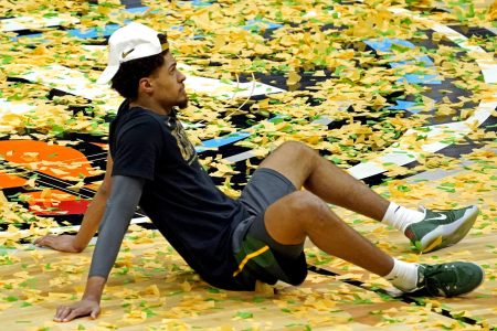 Baylor Bears guard MaCio Teague sits on a confetti-filled basketball court after Baylor beat the Gonzaga Bulldogs to win the 2021 NCAA Tournament championship