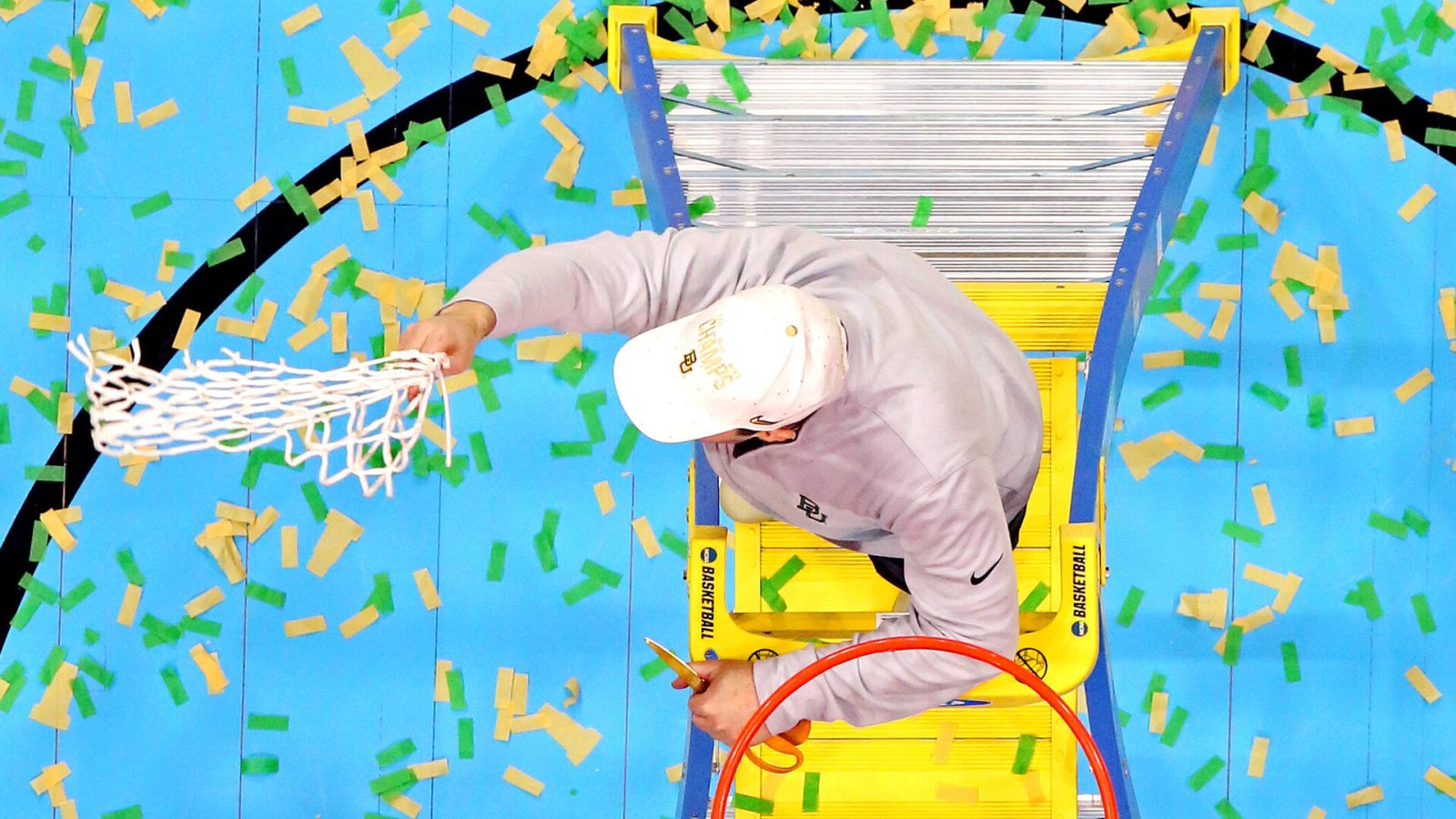 In an overhead shot, Baylor coach Scott Drew (face not seen) waves the basketball net after cutting it off the rim following the Bears' victory over Gonzaga in the 2021 NCAA Tournament men's national championship game at at Lucas Oil Stadium in Indianapolis
