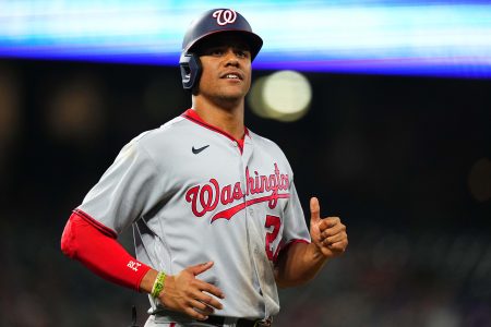 Washington Nationals left fielder Juan Soto jogs to first base with a smile after drawing a walk against the Colorado Rockies