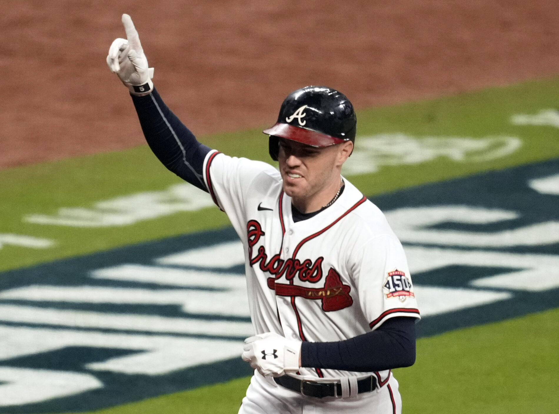 Atlanta Braves first baseman Freddie Freeman raises his right arm and extends his index finger while rounding third base after hitting a home run against the Houston Astros during the 2021 World Series