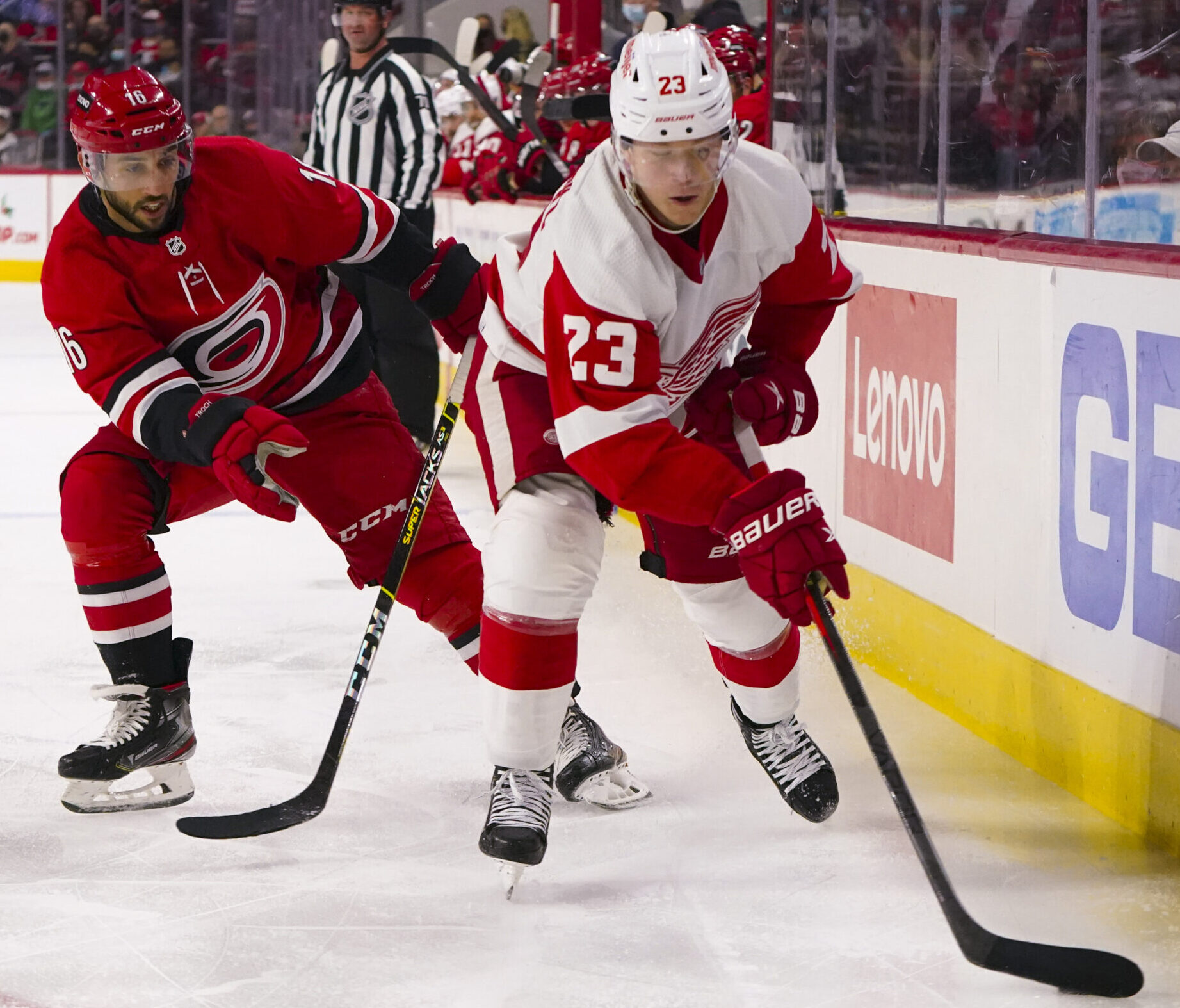 Detroit Red Wings left wing Lucas Raymond (right) skates with the puck as Carolina Hurricanes center Vincent Trocheck (left) pursues from behind
