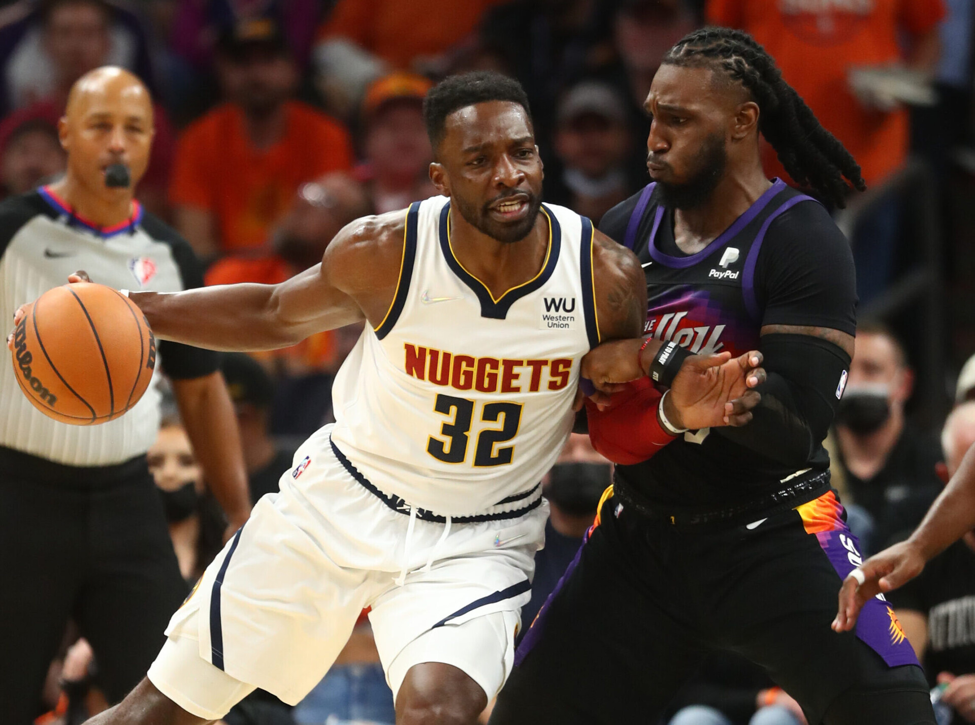 Denver Nuggets forward Jeff Green (left) dribbles the basketball with his right hand as he leans into defending Phoenix Suns forward Jae Crowder (right)