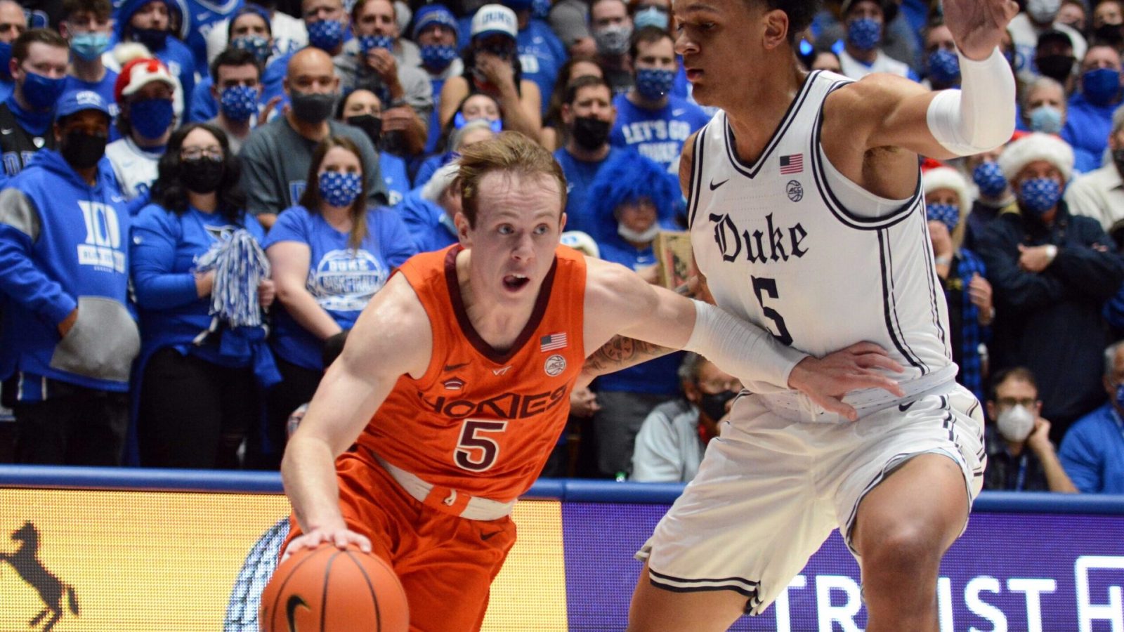 Virginia Tech Hokies guard Storm Murphy (left) dribbles the basketball with his right hand and drives to the basket as Duke Blue Devils forward Paolo Banchero (left) defends during an ACC basketball game
