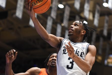 Duke Blue Devils guard Jeremy Roach (right) lays the basketball up with his right hand after driving past Virginia Tech Hokies forward Justyn Mutts (left) during an ACC basketball game