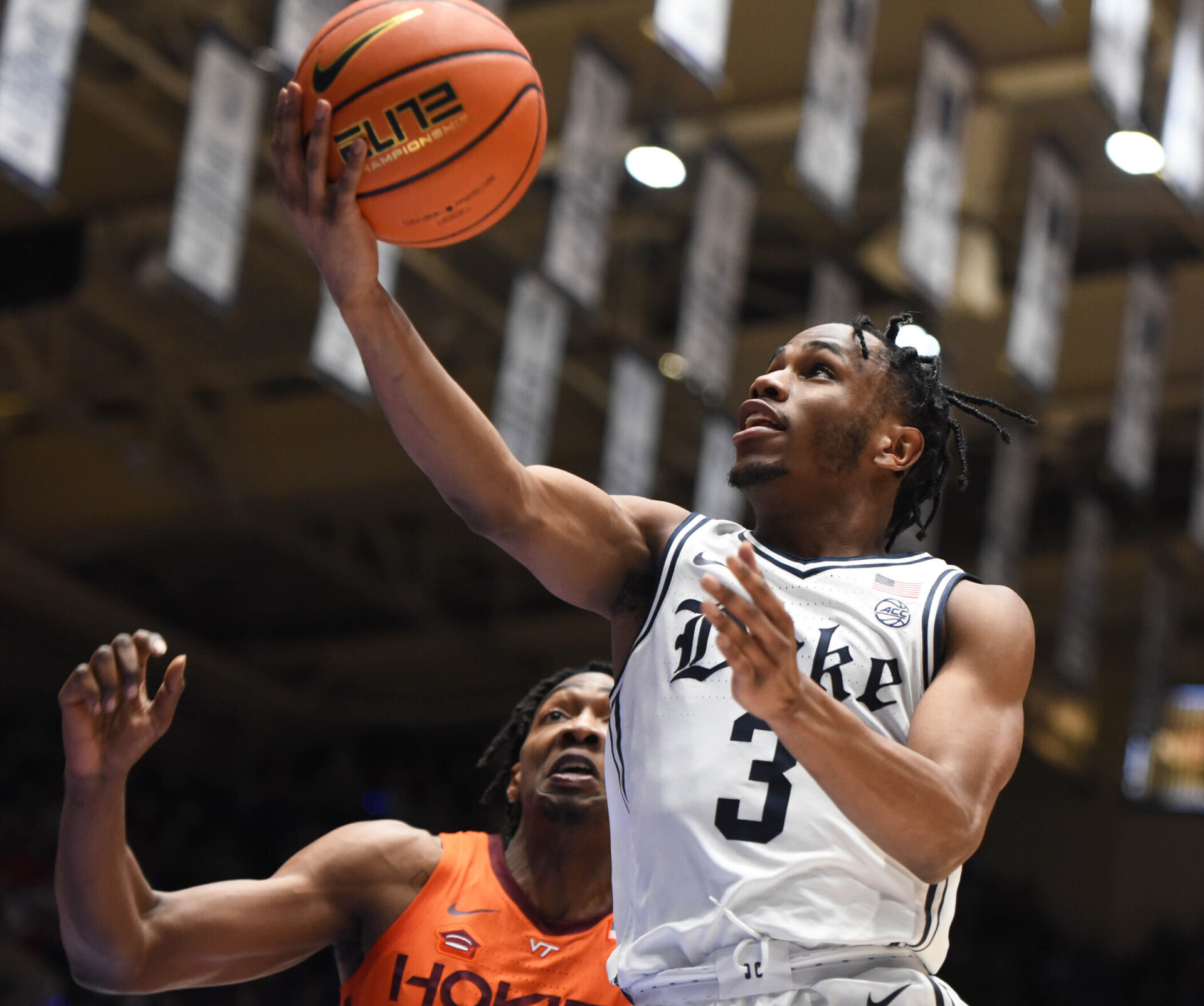 Duke Blue Devils guard Jeremy Roach (right) lays the basketball up with his right hand after driving past Virginia Tech Hokies forward Justyn Mutts (left) during an ACC basketball game