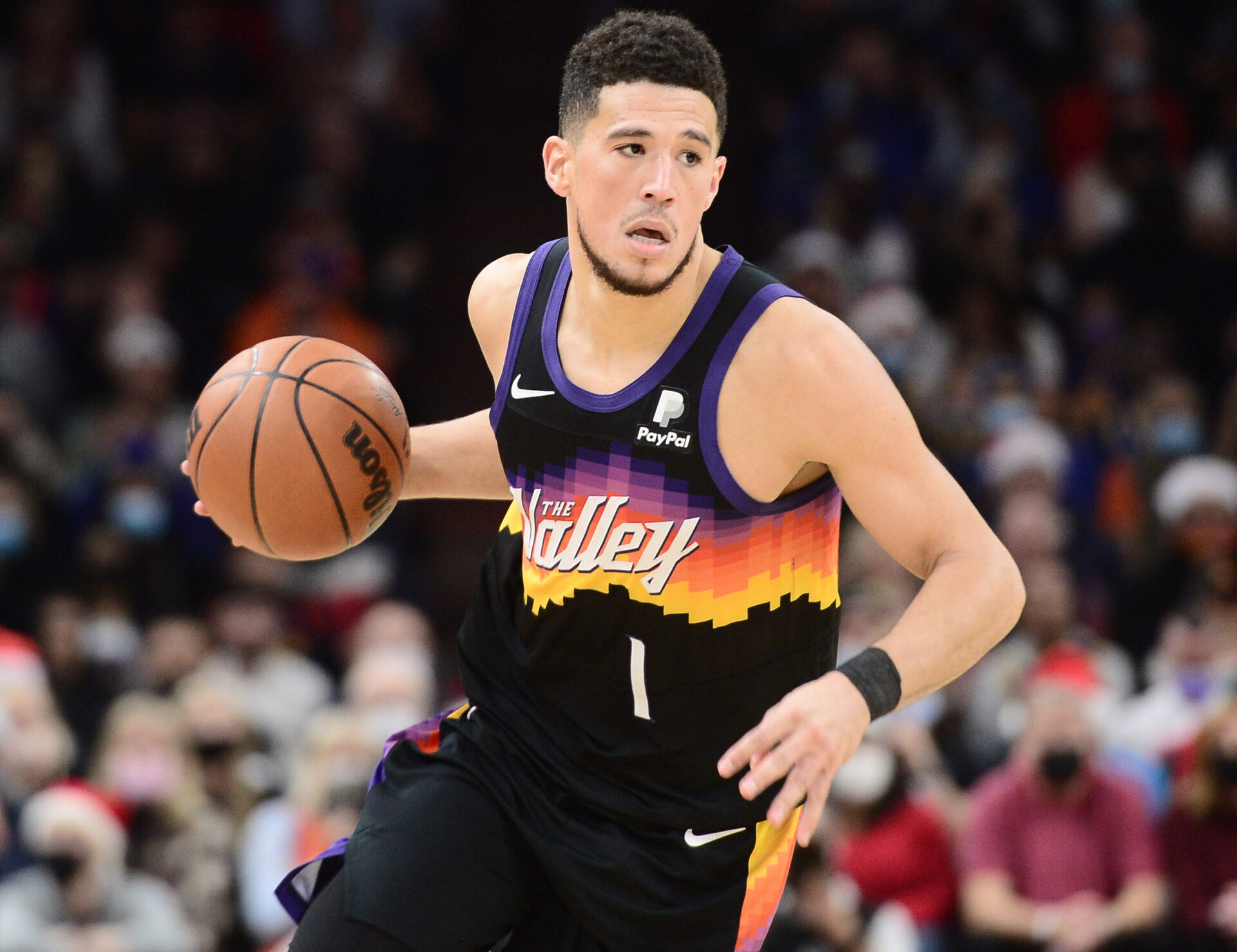 Phoenix Suns guard Devin Booker dribbles the basketball with his right hand as he heads up court against the Golden State Warriors