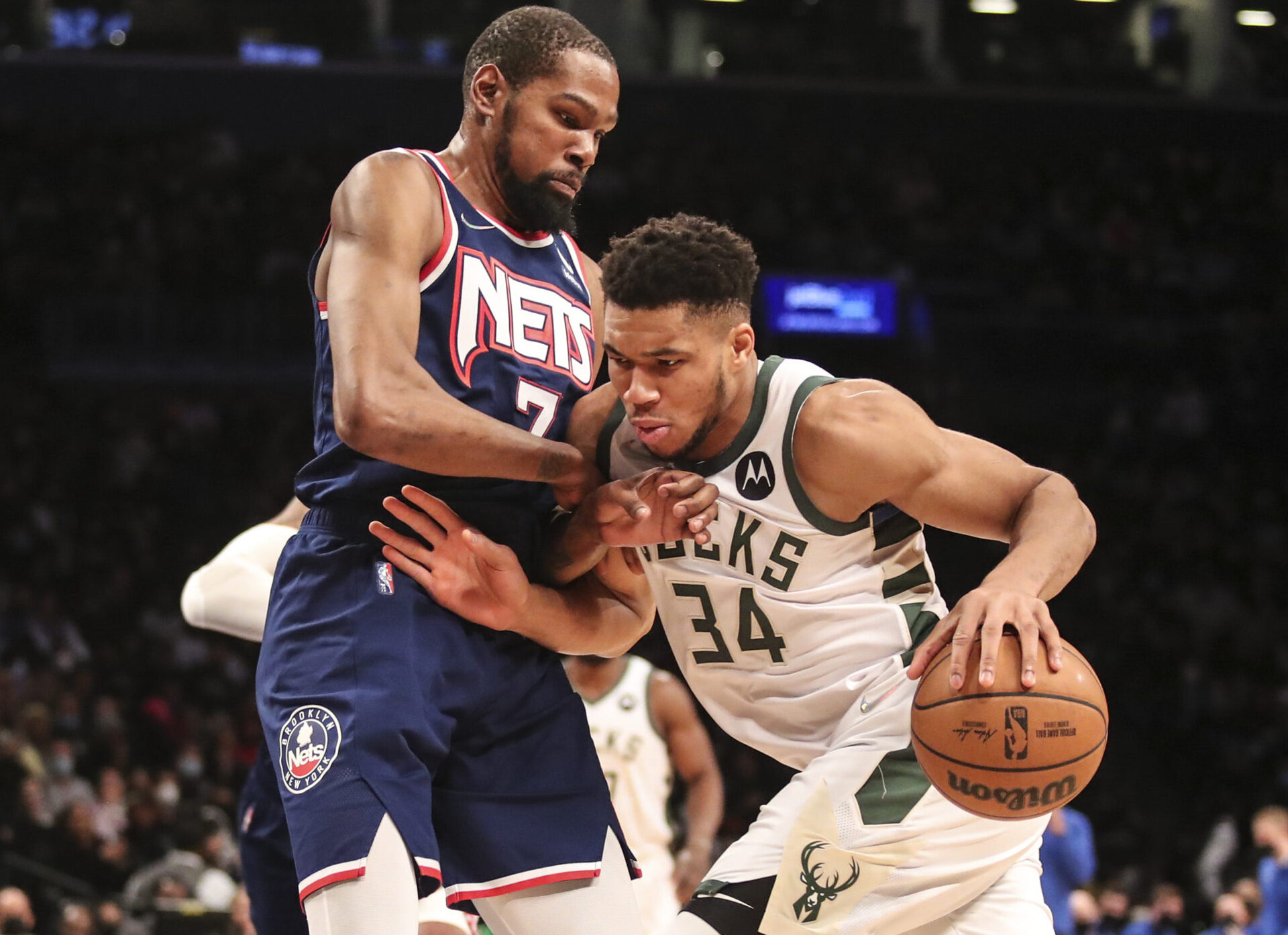 Milwaukee Bucks forward Giannis Antetokounmpo (right) dribbles the ball with his left hand while fending off Brooklyn Nets forward Kevin Durant (left) with his right arm drives as he drives to the basket