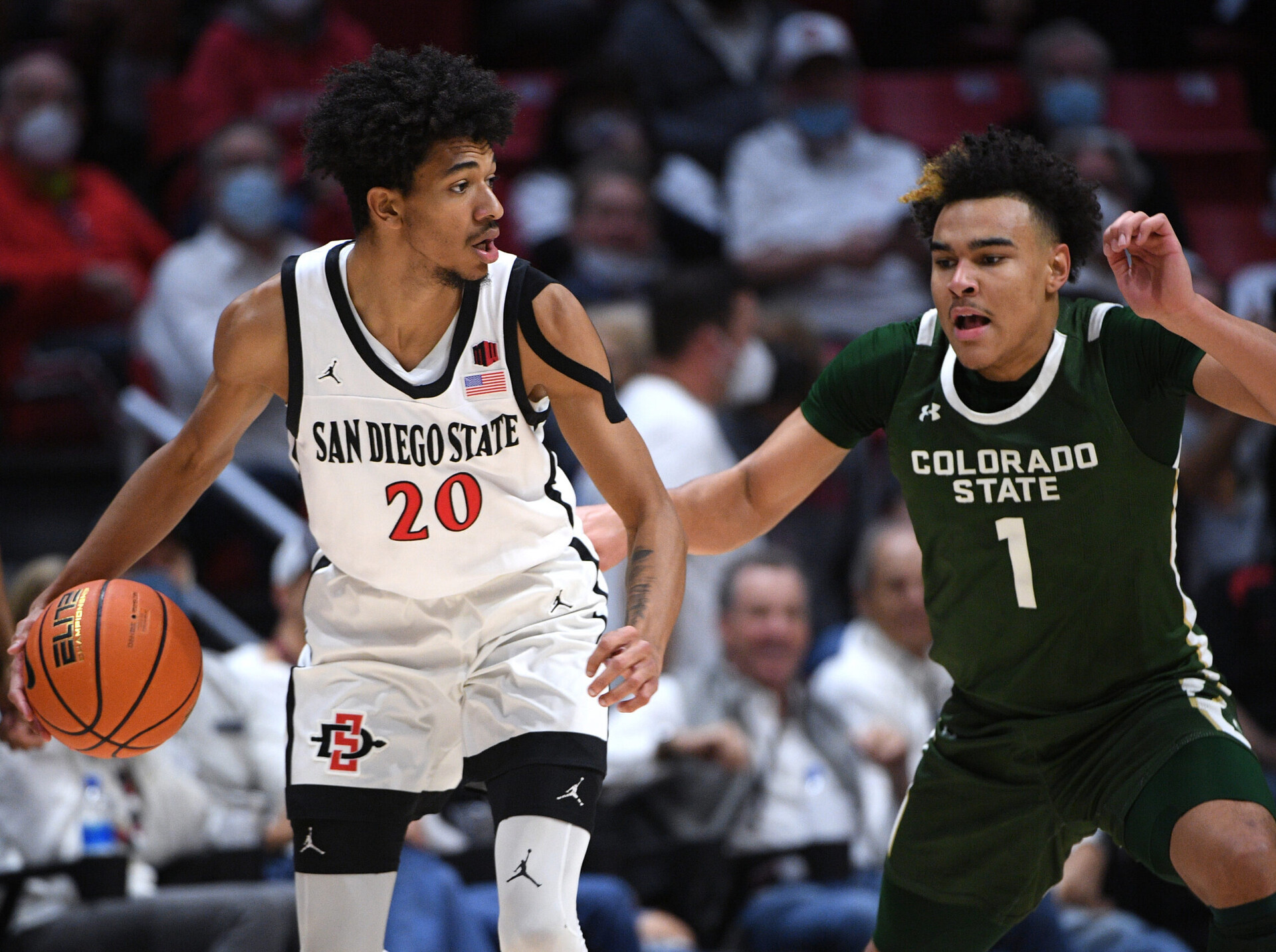 San Diego State Aztecs forward Chad Baker (left) dribbles the basketball with his right hand while defended by Colorado State Rams guard Trace Young (right) during a Mountain West conference basketball game