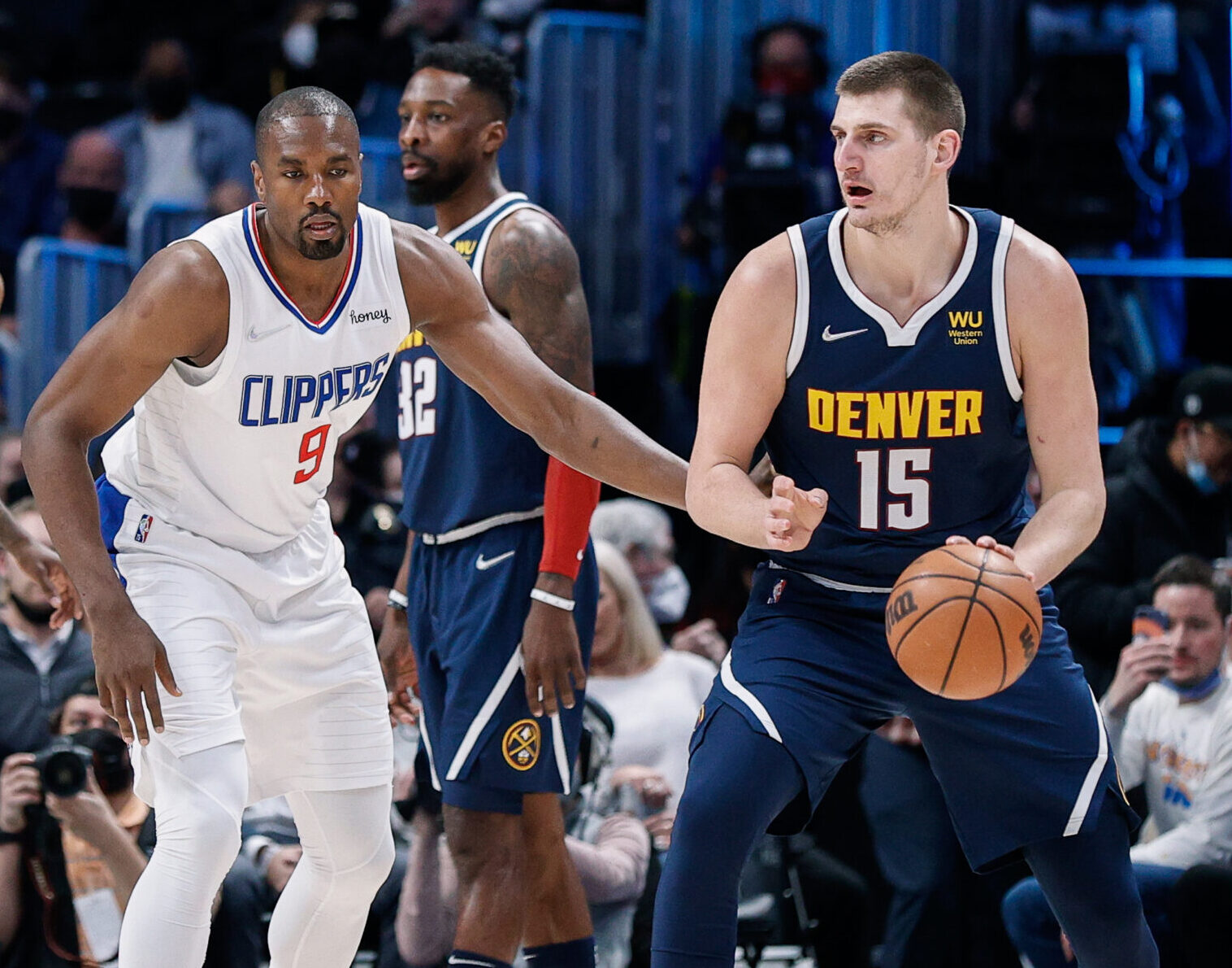 Denver Nuggets center Nikola Jokic (right) dribbles the ball with his left hand as Los Angeles Clippers center Serge Ibaka (left) defends