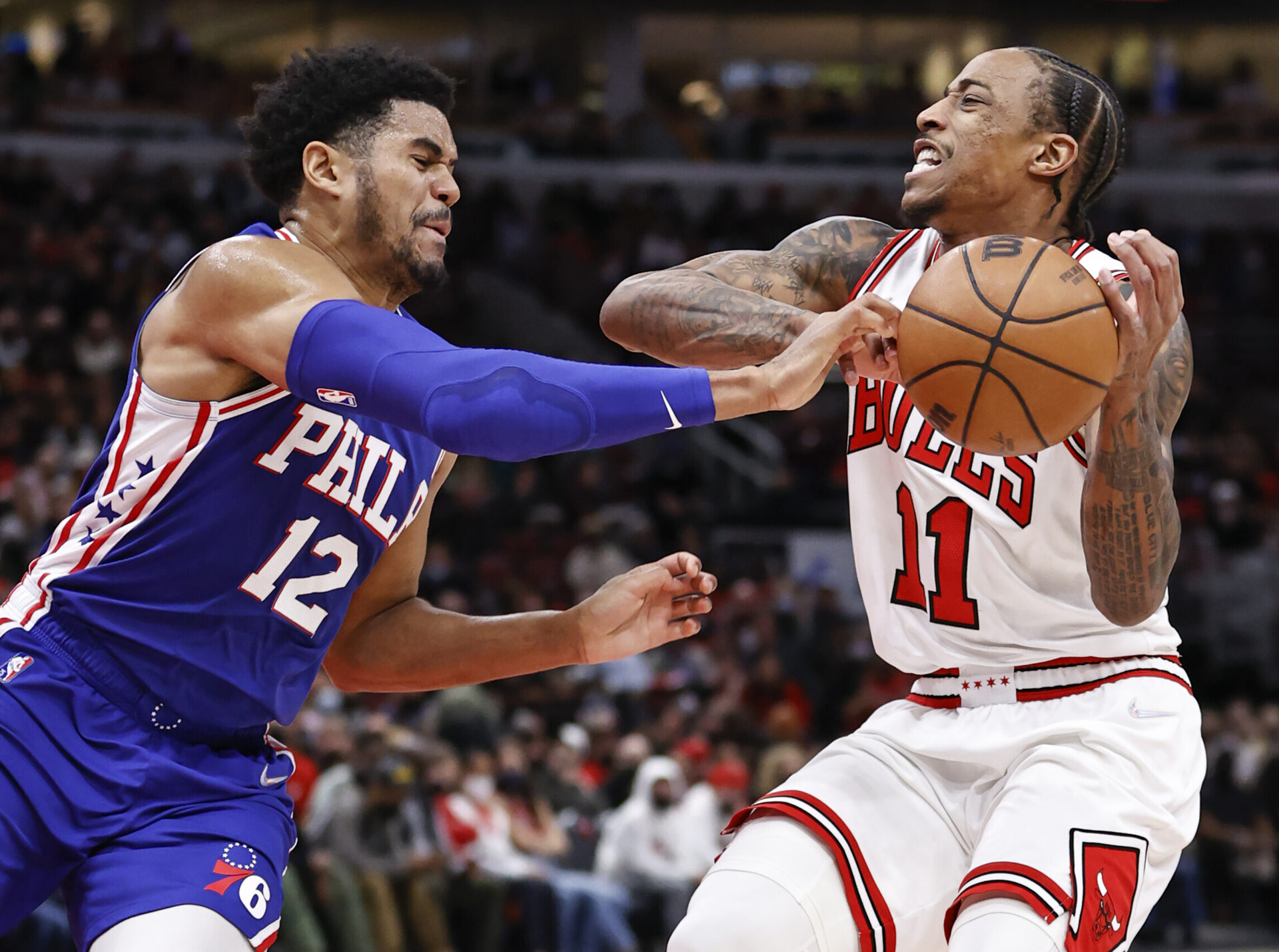 Philadelphia 76ers forward Tobias Harris (left) thrusts his right hand forward and tries to strip the ball from Chicago Bulls forward DeMar DeRozan