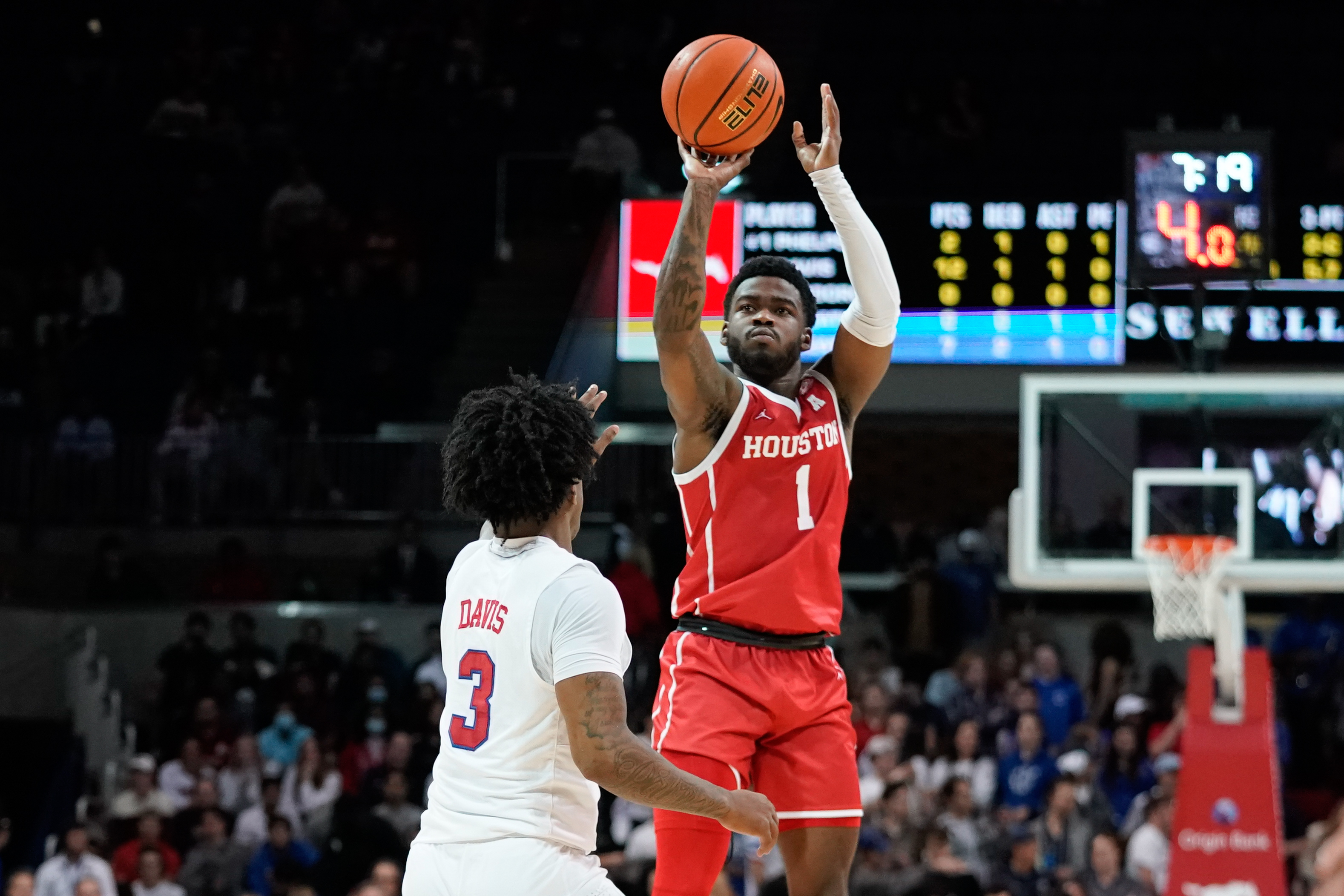 Houston Cougars guard Jamal Shead (right) rises up and shoots the basketball with his right hand over Southern Methodist Mustangs guard Kendric Davis (left) during an American Athletic Conference game