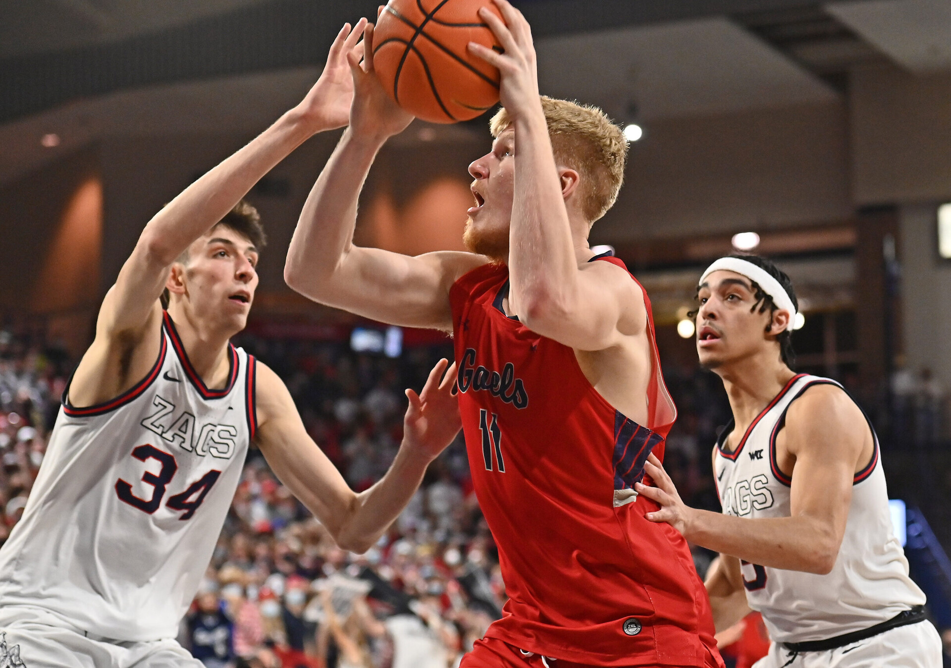 St. Mary's Gaels forward Matthias Tass (center) shoots the ball with his right hand against Gonzaga Bulldogs center Chet Holmgren (left) during a West Coast Conference basketball game