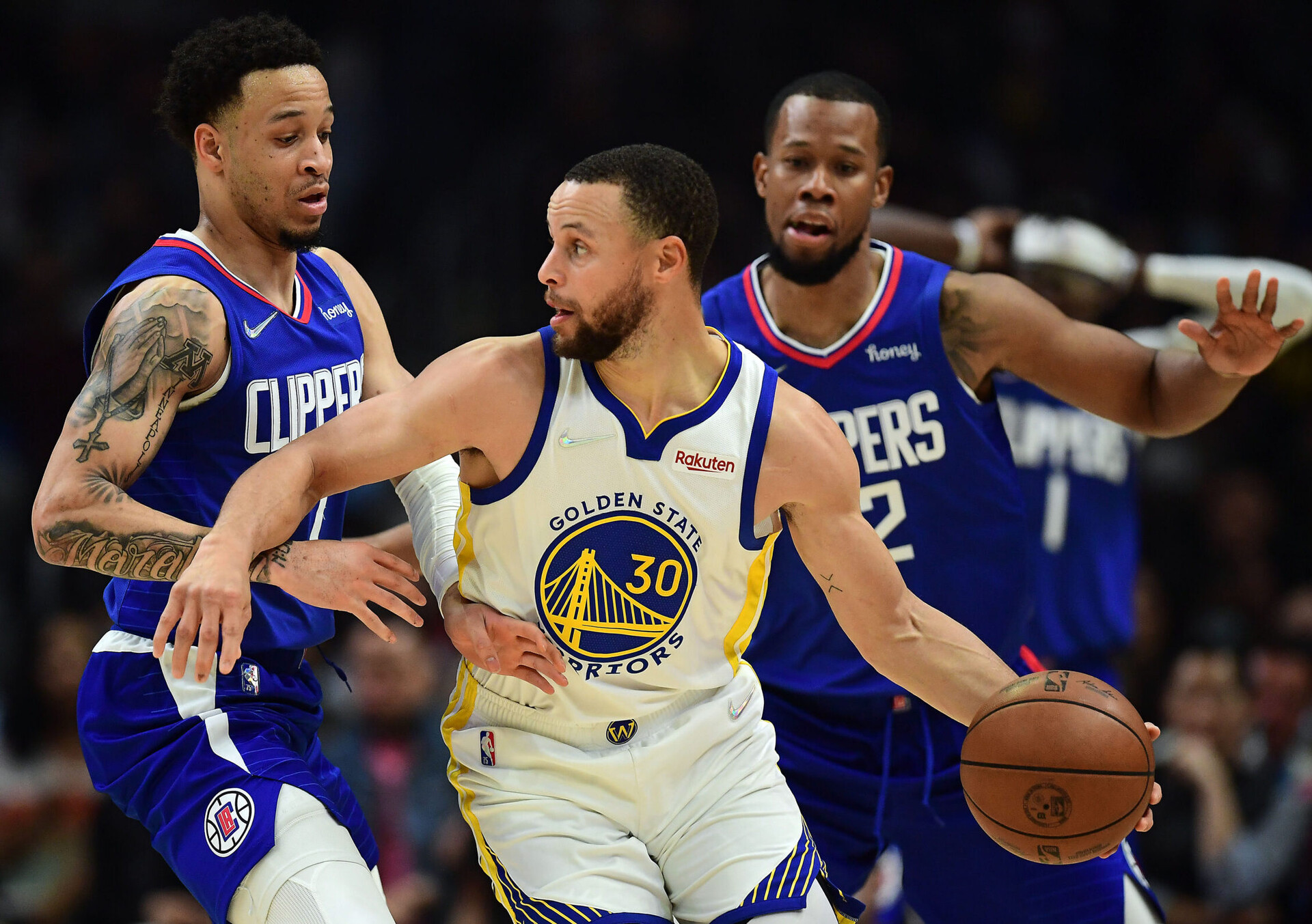 Golden State Warriors guard Stephen Curry (right) dribbles the basketball with his left hand will trying to make a move around Los Angeles Clippers guard Amir Coffey (left)
