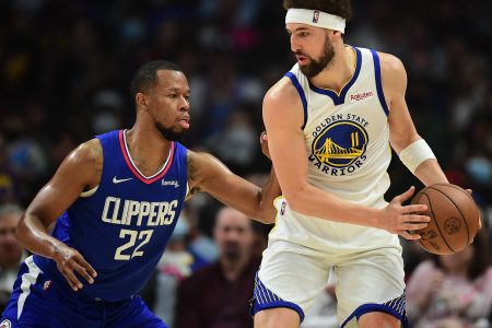 Golden State Warriors guard Klay Thompson (right) controls the ball with both hands as Los Angeles Clippers Los Angeles Clippers guard Rodney Hood (left) applies defensive pressure