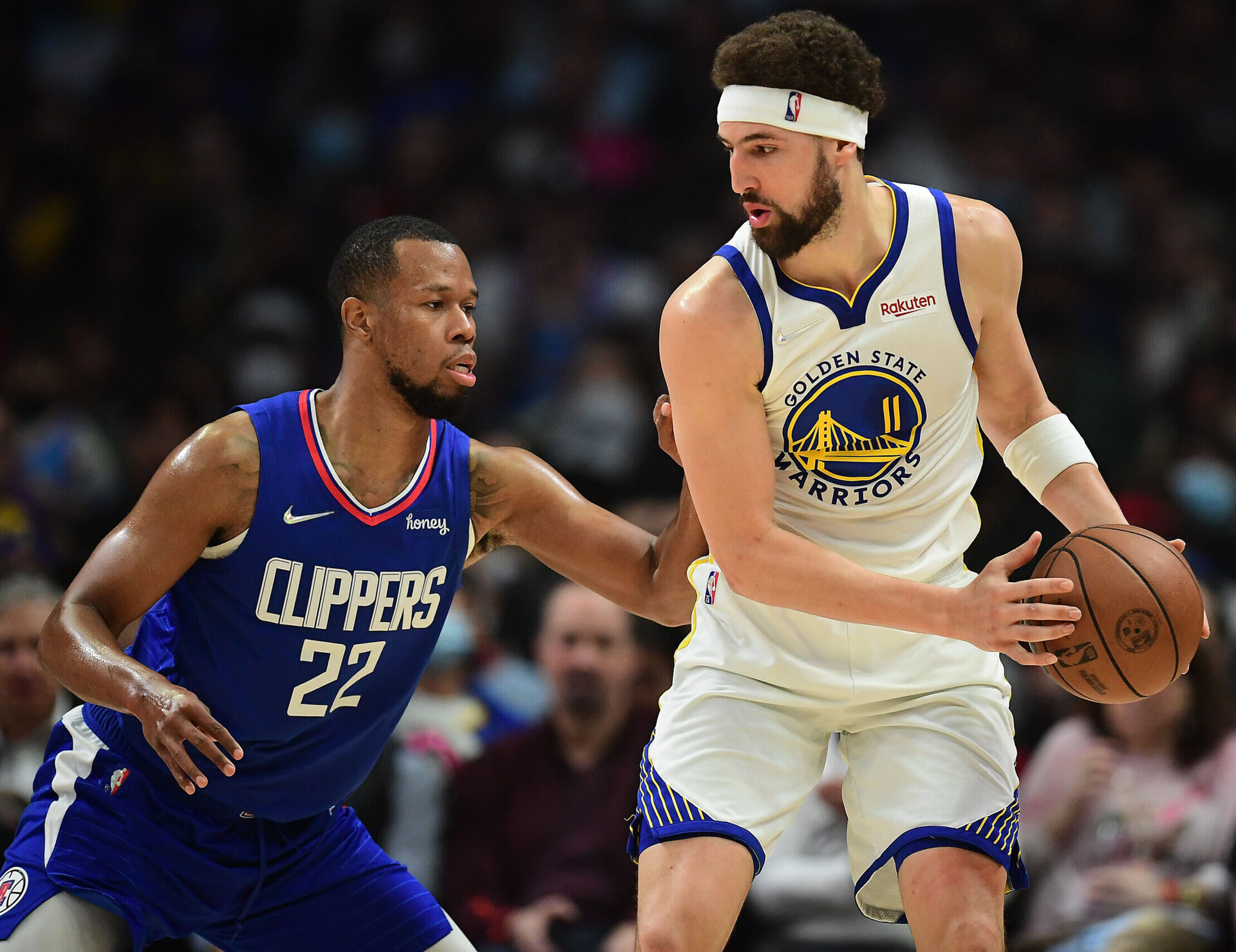 Golden State Warriors guard Klay Thompson (right) controls the ball with both hands as Los Angeles Clippers Los Angeles Clippers guard Rodney Hood (left) applies defensive pressure