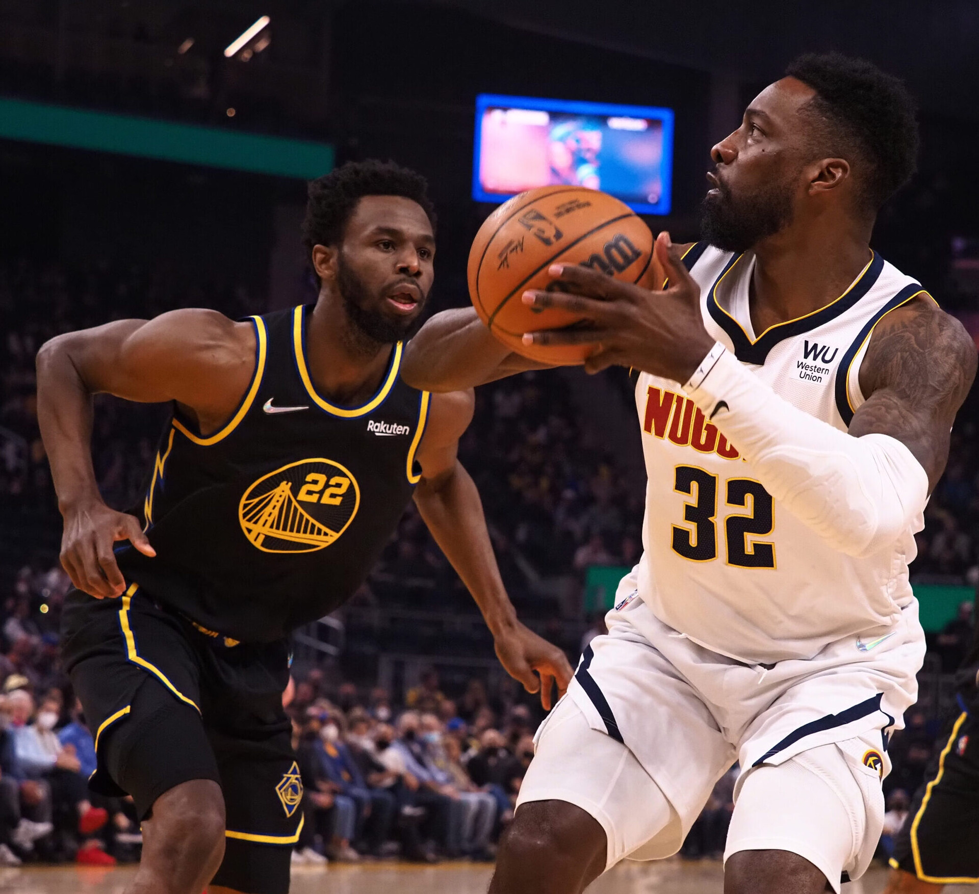 Denver Nuggets forward Jeff Green (left) clutches the basketball with both hands and prepares to take a shot as Golden State Warriors forward Andrew Wiggins (left) closes in on defense