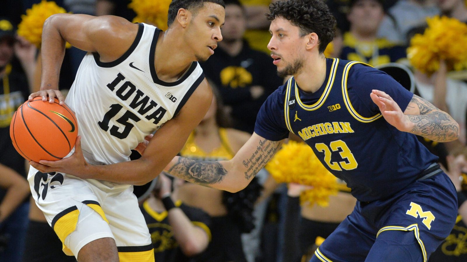 Iowa Hawkeyes forward Keegan Murray (left) controls the ball as Michigan Wolverines forward Brandon Johns Jr. (right) defends during a Big Ten basketball game