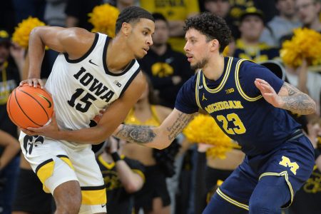 Iowa Hawkeyes forward Keegan Murray (left) controls the ball as Michigan Wolverines forward Brandon Johns Jr. (right) defends during a Big Ten basketball game