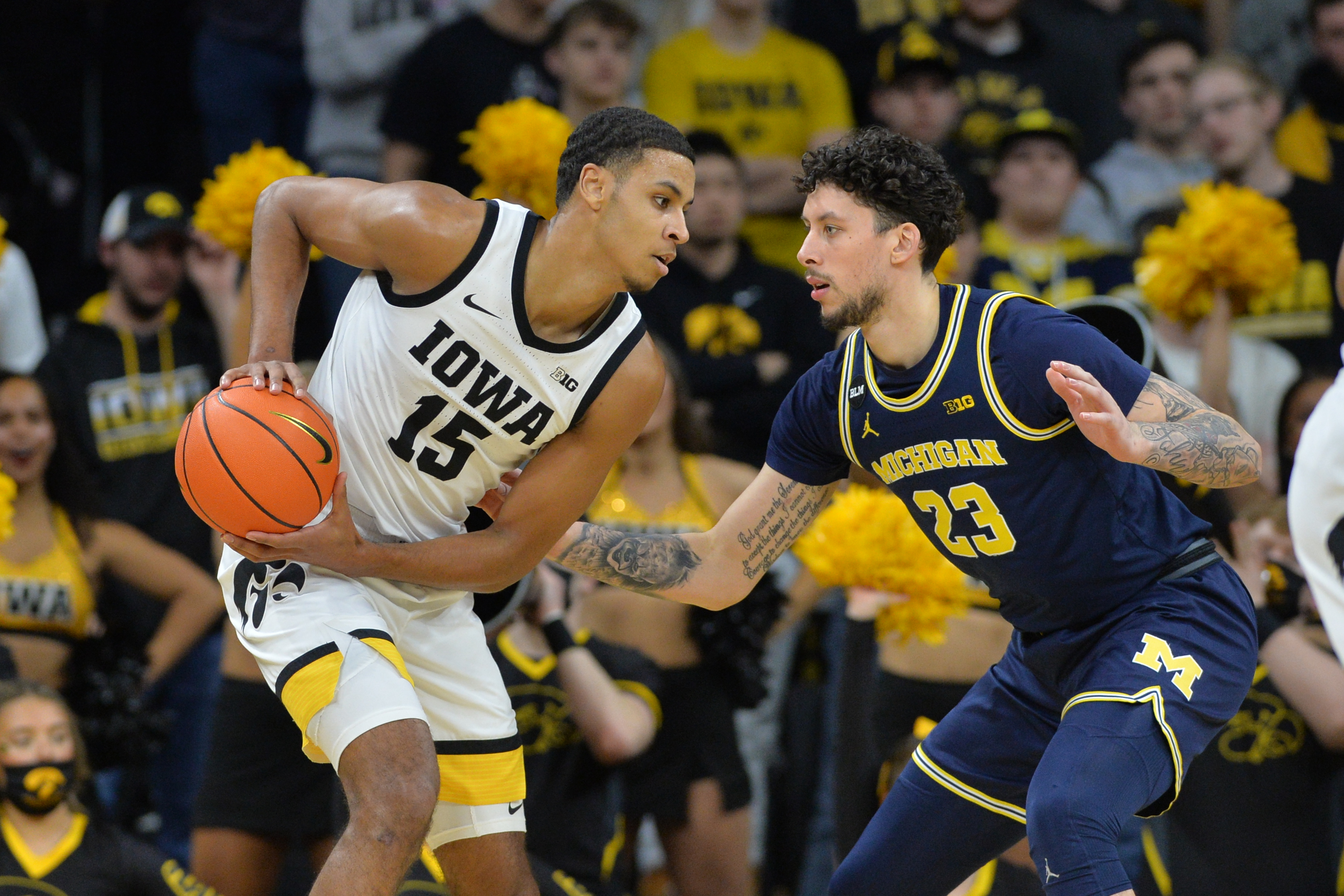 Iowa Hawkeyes forward Keegan Murray (left) controls the ball as Michigan Wolverines forward Brandon Johns Jr. (right) defends during a Big Ten basketball game