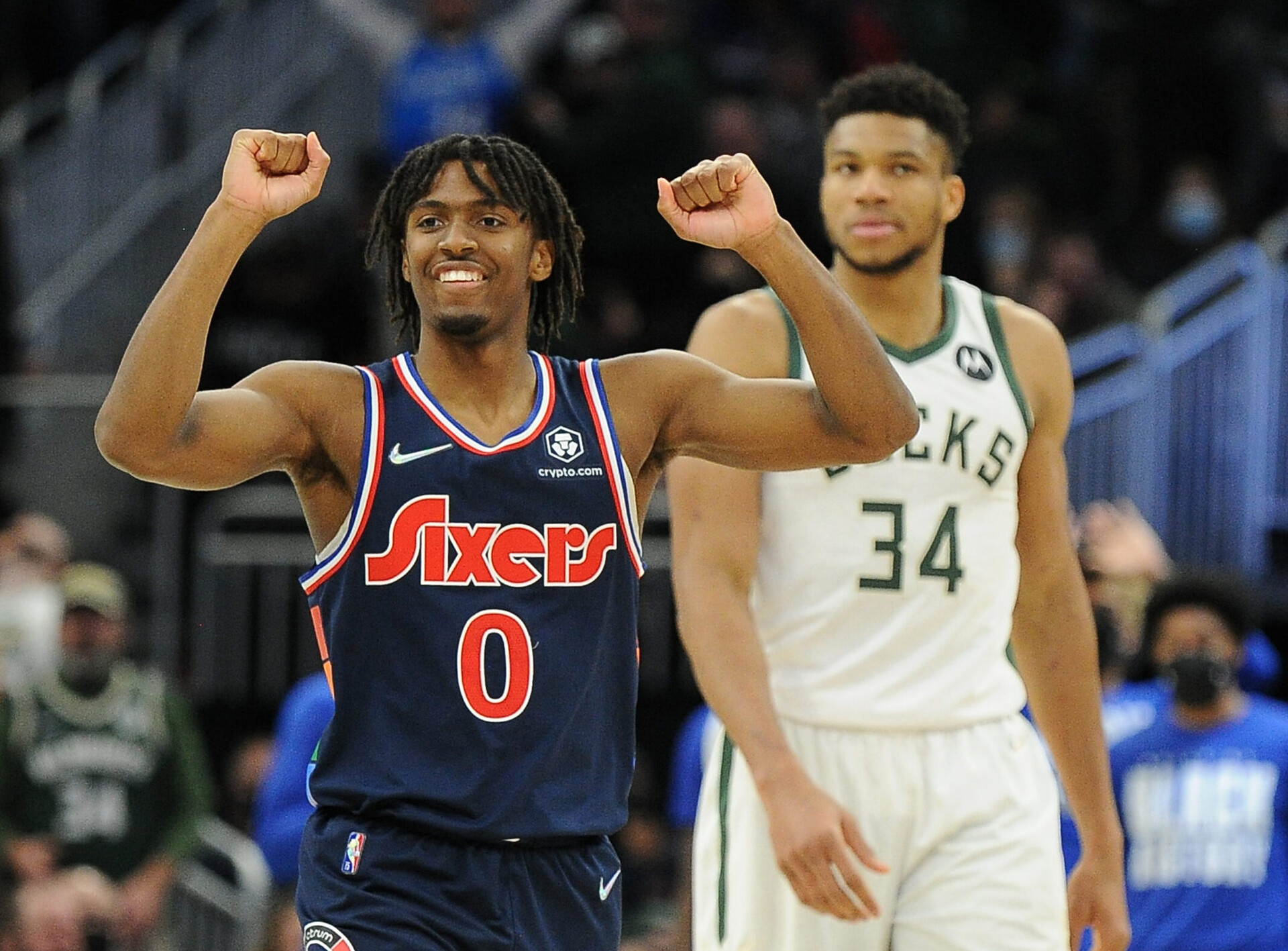 Philadelphia 76ers guard Tyrese Maxey (left) raises both arms with clenched fists in celebration of a win over the Milwaukee Bucks while Bucks center Giannis Antetokounmpo (right) looks on in the background