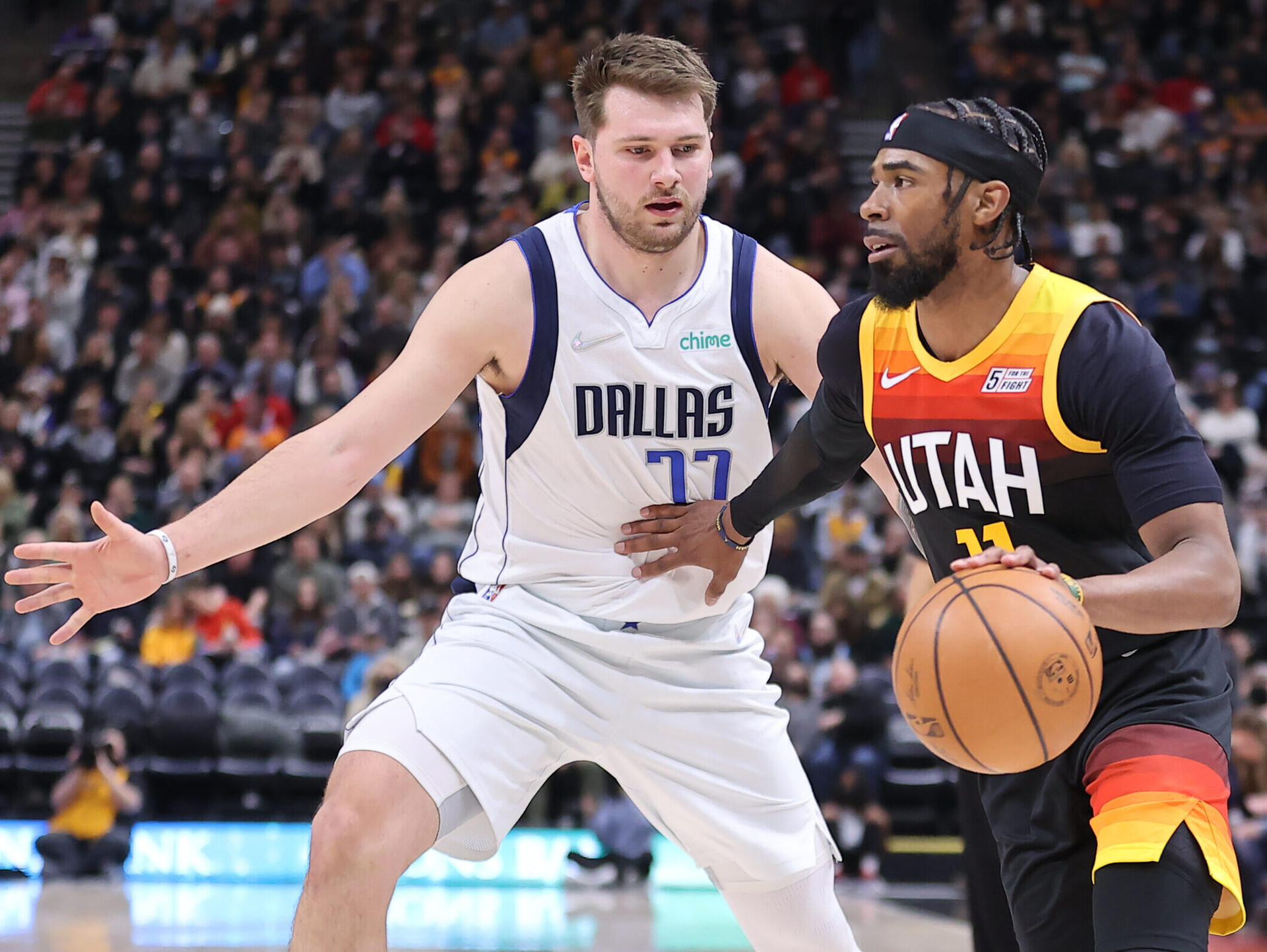 Utah Jazz guard Mike Conley (right) dribbles the ball with his left hand as he looks to get past Dallas Mavericks guard Luka Doncic (left)