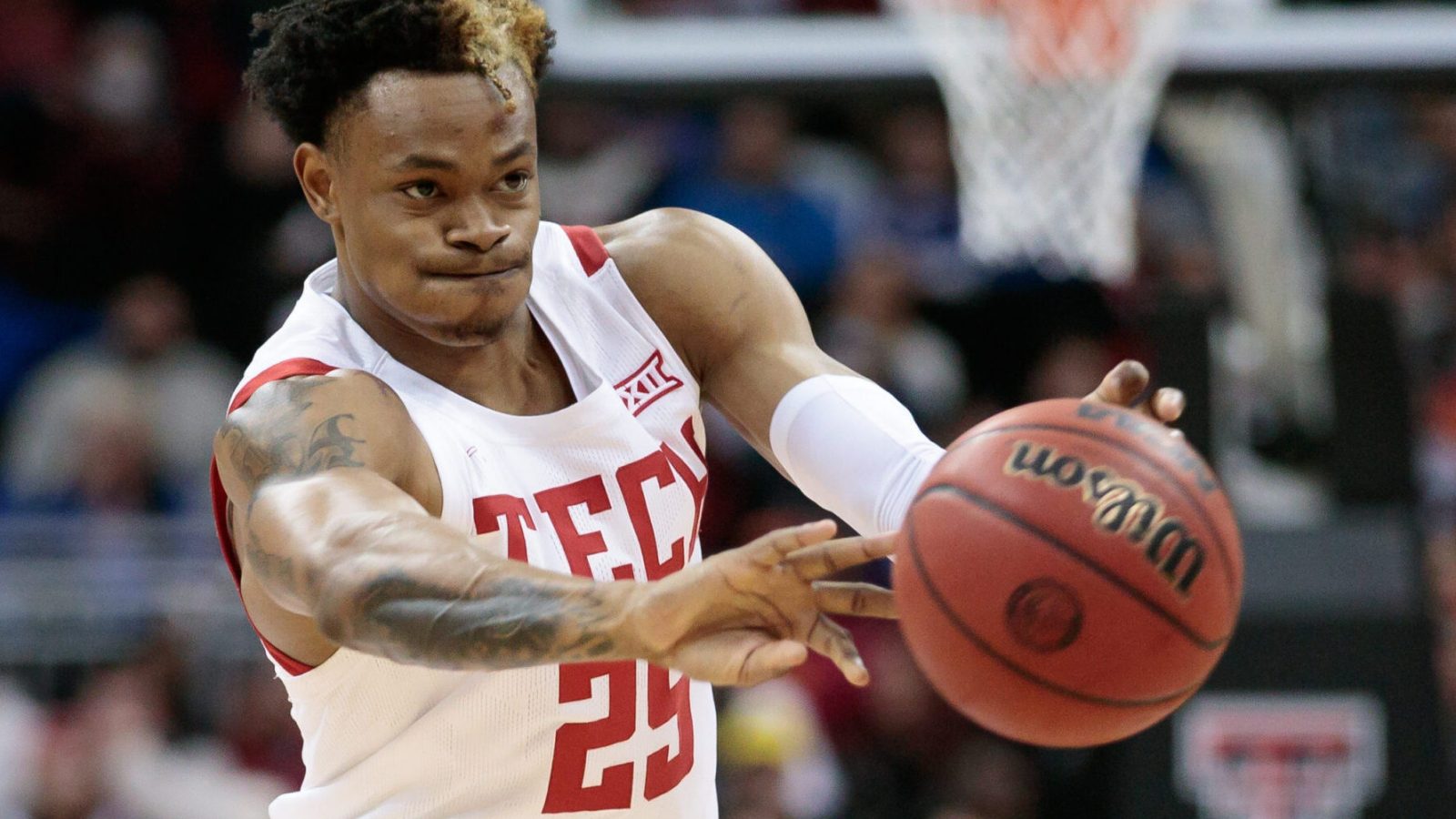 Texas Tech Red Raiders guard Adonis Arms passes the ball with both hands outstretched during a Big 12 basketball game against the Iowa State Cyclones
