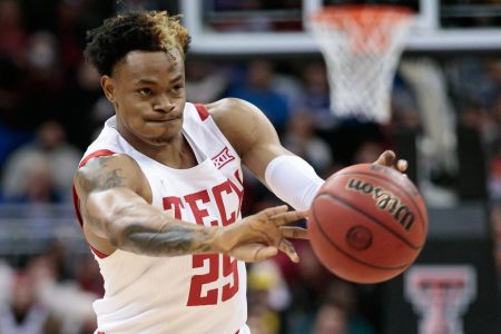 Texas Tech Red Raiders guard Adonis Arms passes the ball with both hands outstretched during a Big 12 basketball game against the Iowa State Cyclones
