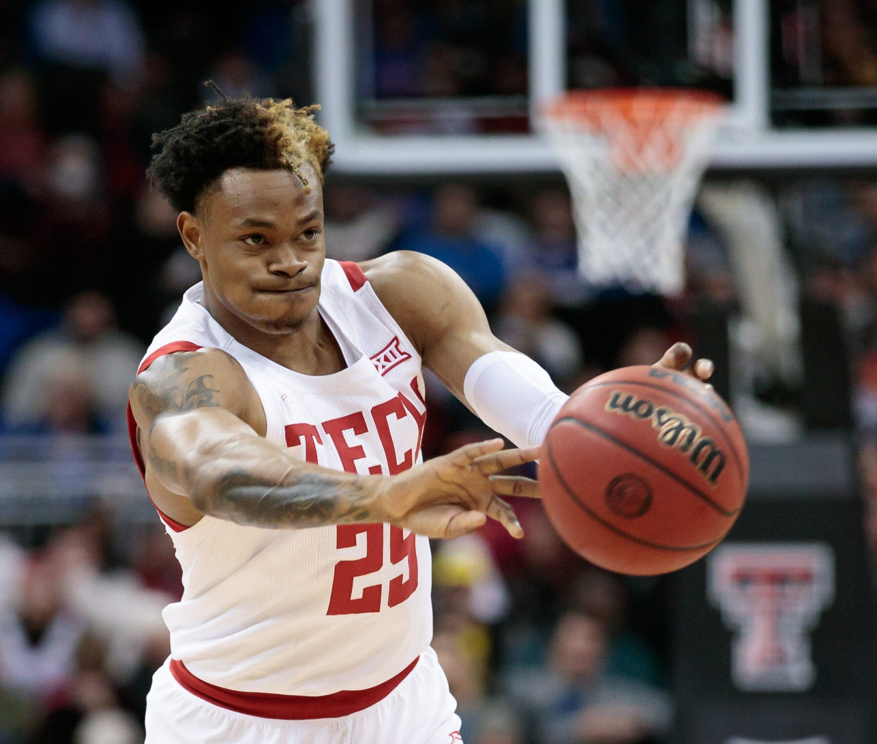 Texas Tech Red Raiders guard Adonis Arms passes the ball with both hands outstretched during a Big 12 basketball game against the Iowa State Cyclones