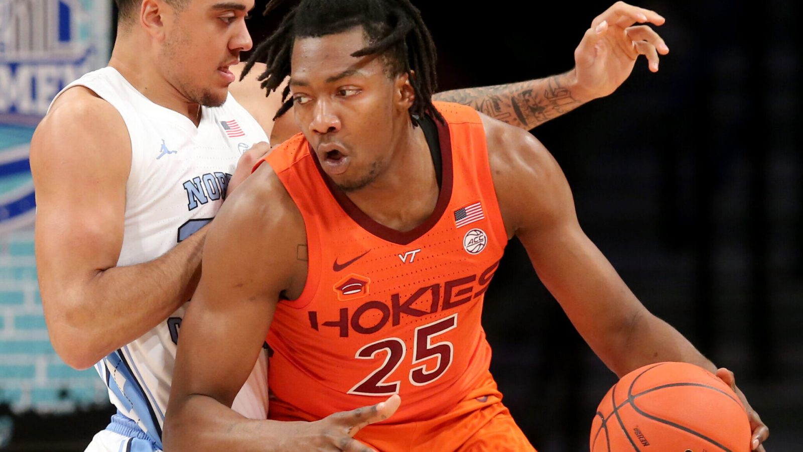 Virginia Tech Hokies forward Justyn Mutts (right) dribbles the basketball wit his left hand while trying to make a play against defending North Carolina Tar Heels forward Justin McKoy (left) during the ACC tournament
