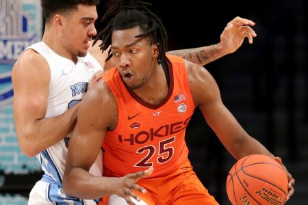 Virginia Tech Hokies forward Justyn Mutts (right) dribbles the basketball wit his left hand while trying to make a play against defending North Carolina Tar Heels forward Justin McKoy (left) during the ACC tournament