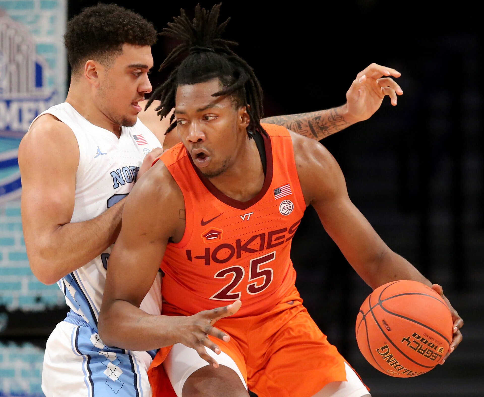 Virginia Tech Hokies forward Justyn Mutts (right) dribbles the basketball wit his left hand while trying to make a play against defending North Carolina Tar Heels forward Justin McKoy (left) during the ACC tournament