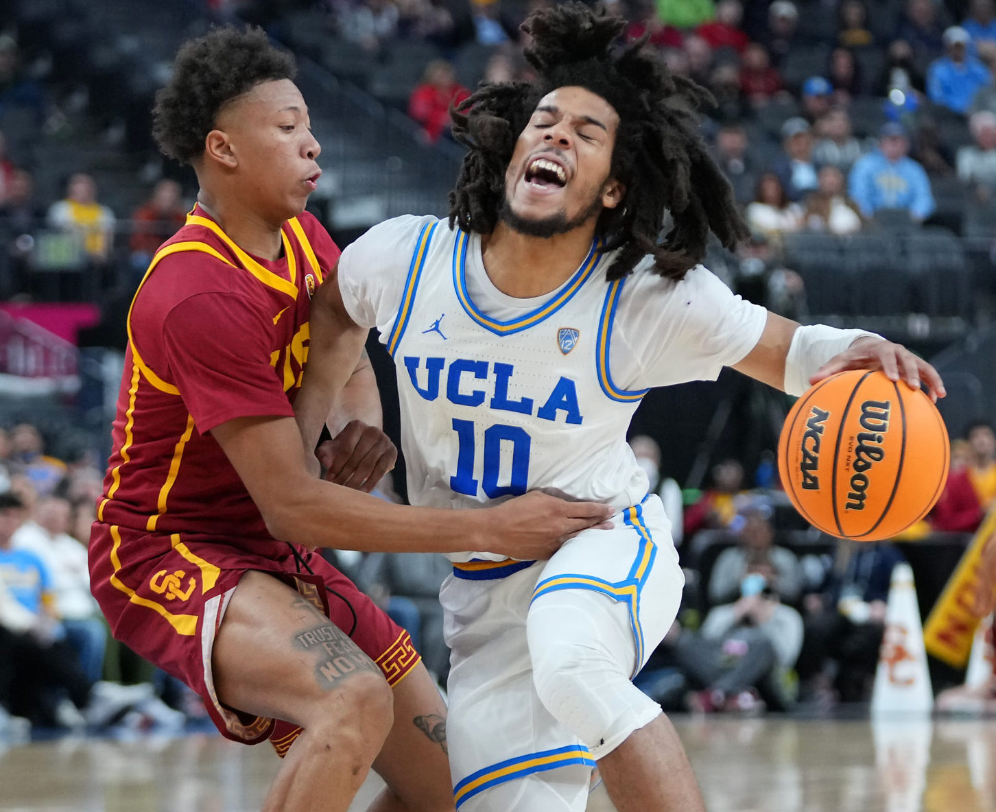 UCLA Bruins guard Tyger Campbell (10) is fouled by USC Trojans guard Boogie Ellis (0) during the second half at T-Mobile Arena in Las Vegas on March 11, 2022.