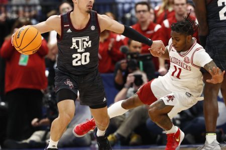 Arkansas Razorbacks forward Kamani Johnson (20) drives to the basket as Arkansas Razorbacks guard Chris Lykes (11) defends during the first half at Amalie Arena in Tampa, Fla., on March 12, 2022.