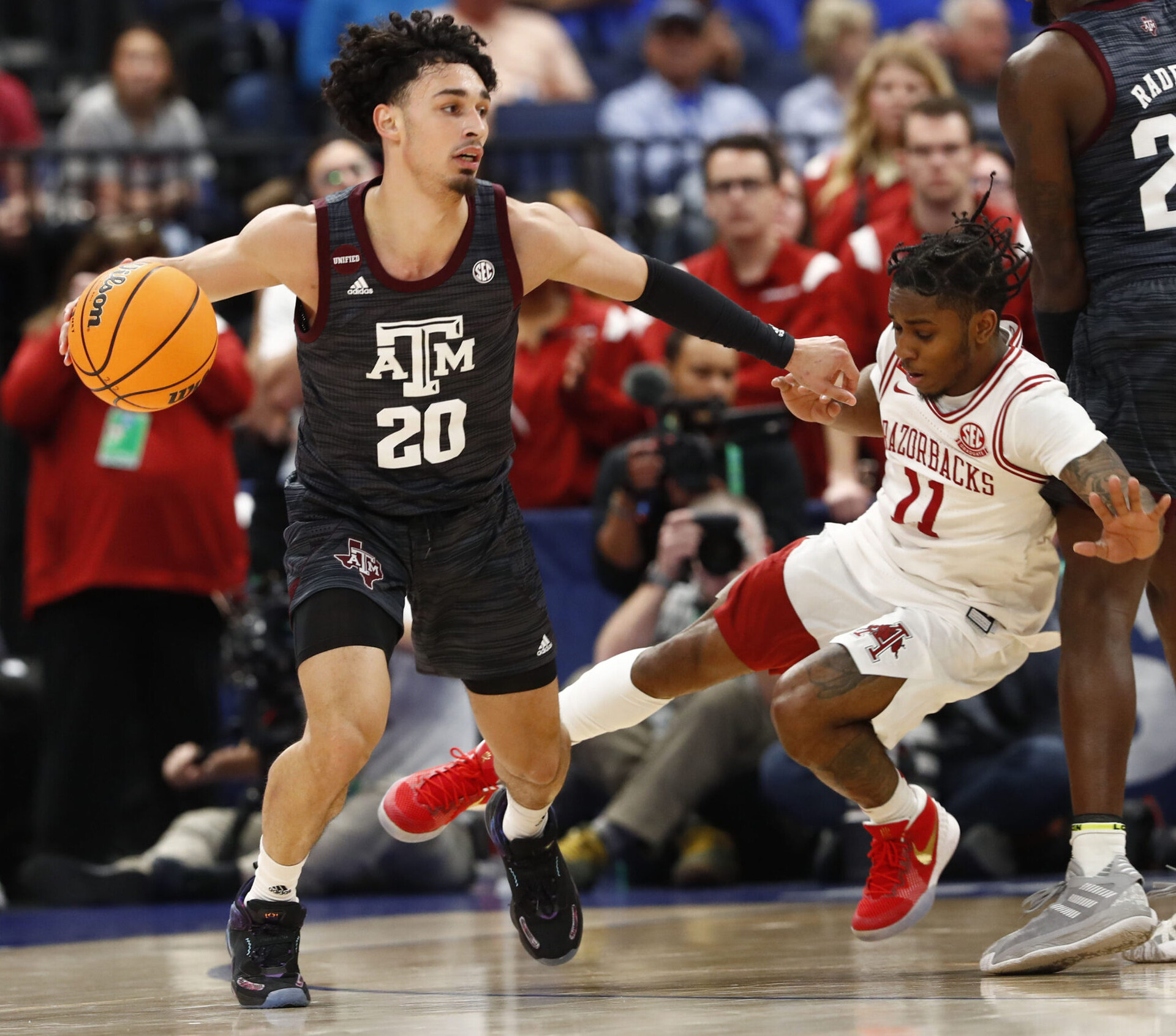 Arkansas Razorbacks forward Kamani Johnson (20) drives to the basket as Arkansas Razorbacks guard Chris Lykes (11) defends during the first half at Amalie Arena in Tampa, Fla., on March 12, 2022.