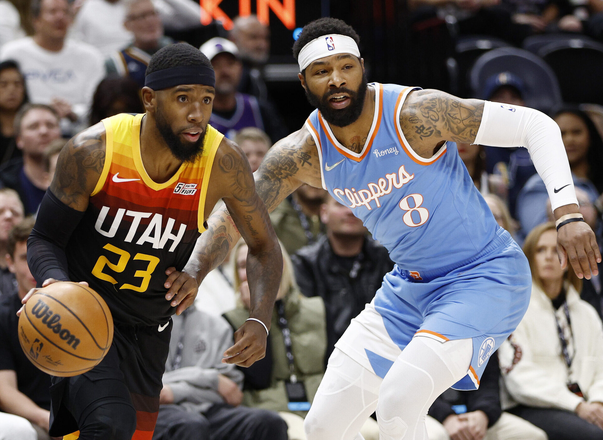 Utah Jazz forward Royce O'Neale (left) dribbles the ball with his right hand as he tries to drive past LA Clippers forward Marcus Morris Sr. (right)
