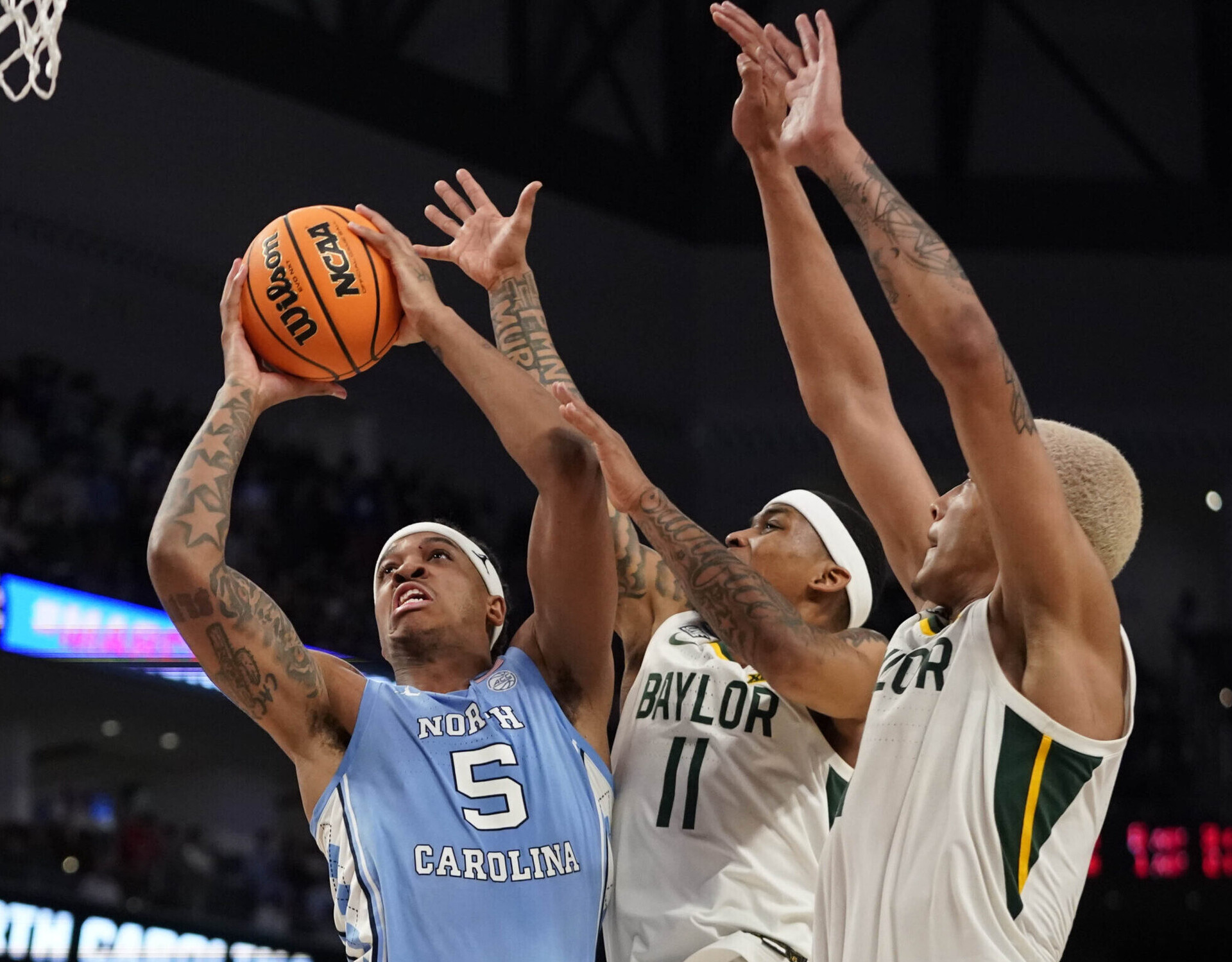 North Carolina Tar Heels forward Armando Bacot (5) shoots against Baylor Bears guard James Akinjo (11) and Baylor Bears forward Jeremy Sochan (1) during the second round of the 2022 NCAA Tournament at Dickies Arena on Sunday, March 20, in Fort Worth, Texas.