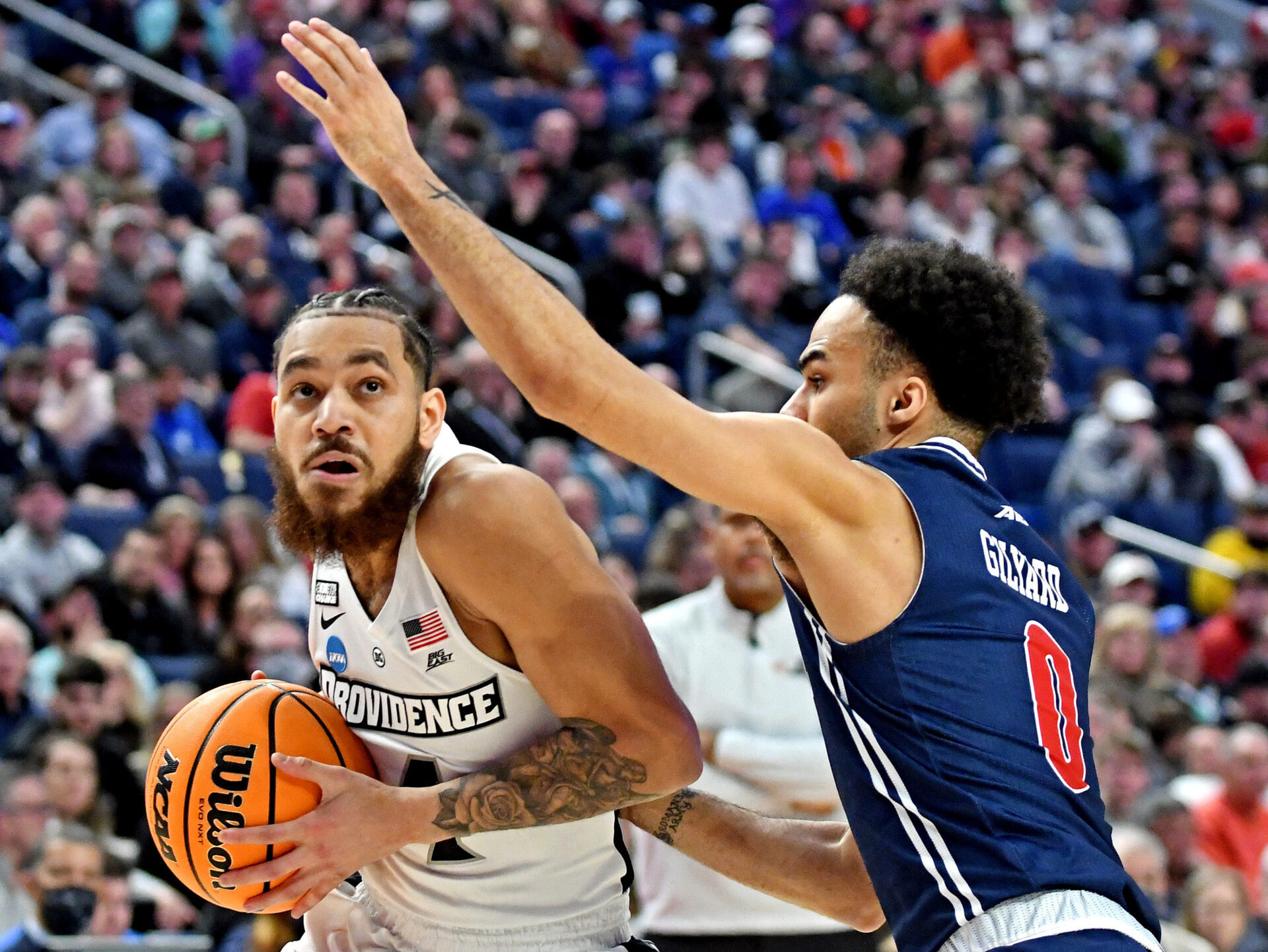 Providence Friars guard Jared Bynum (left) controls the basketball with both hands and drives to the basket asRichmond Spiders guard Jacob Gilyard (right) defends during the second round of the 2022 NCAA Tournament